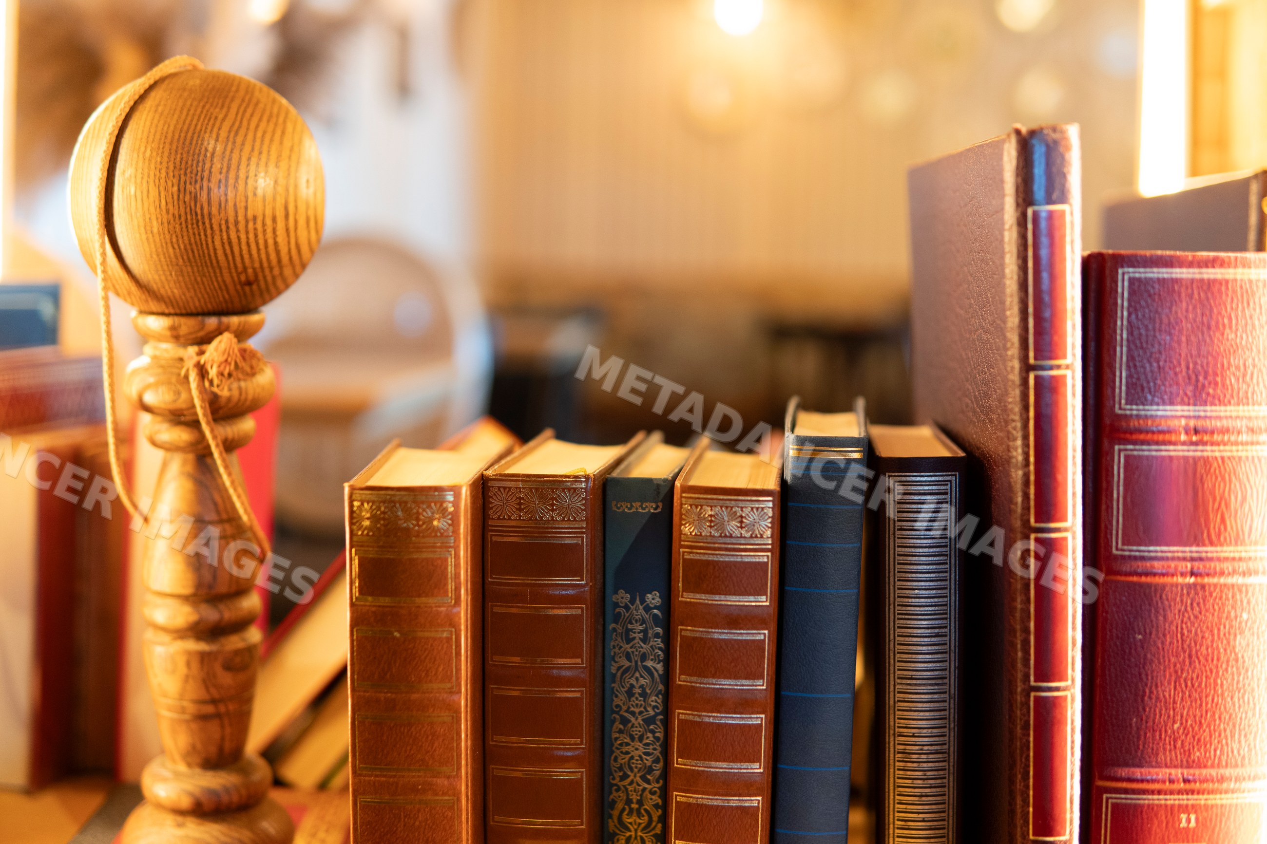 Antique leather-bound books displayed with a wooden spindle