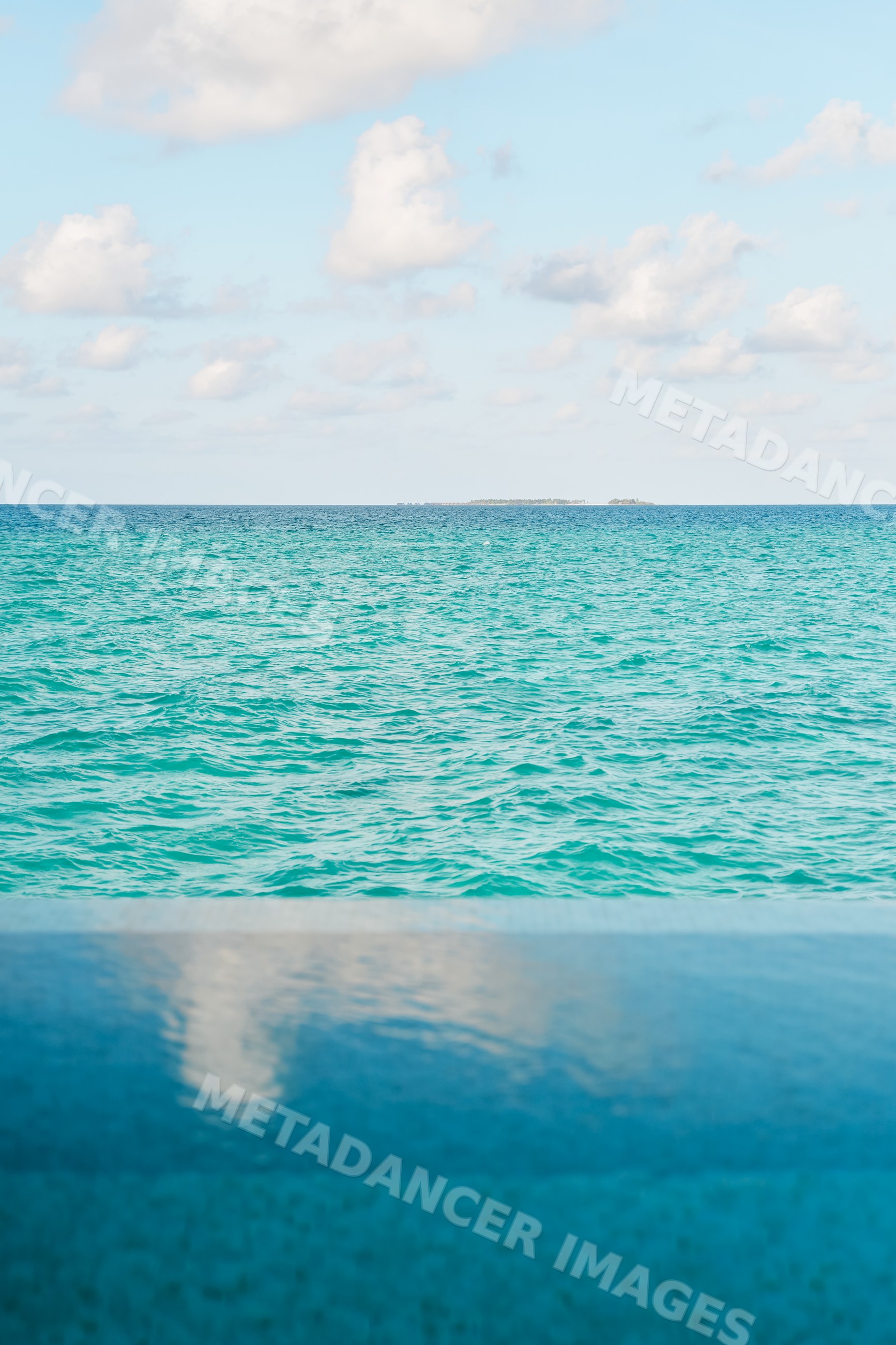 A turquoise sea and infinity pool with distant islands