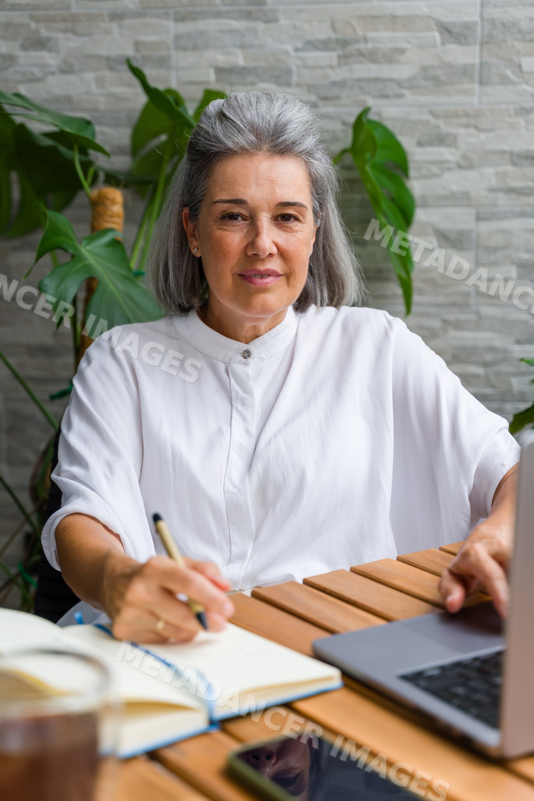 Mature gray-haired white woman writing