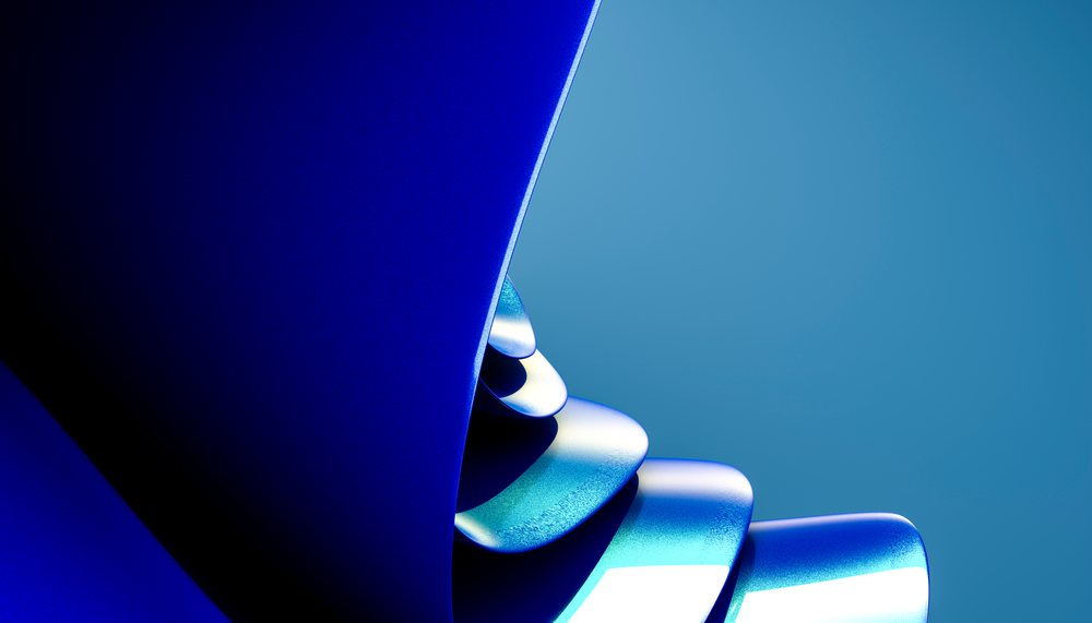 Blue abstract curved metal sculpture with layered design in studio