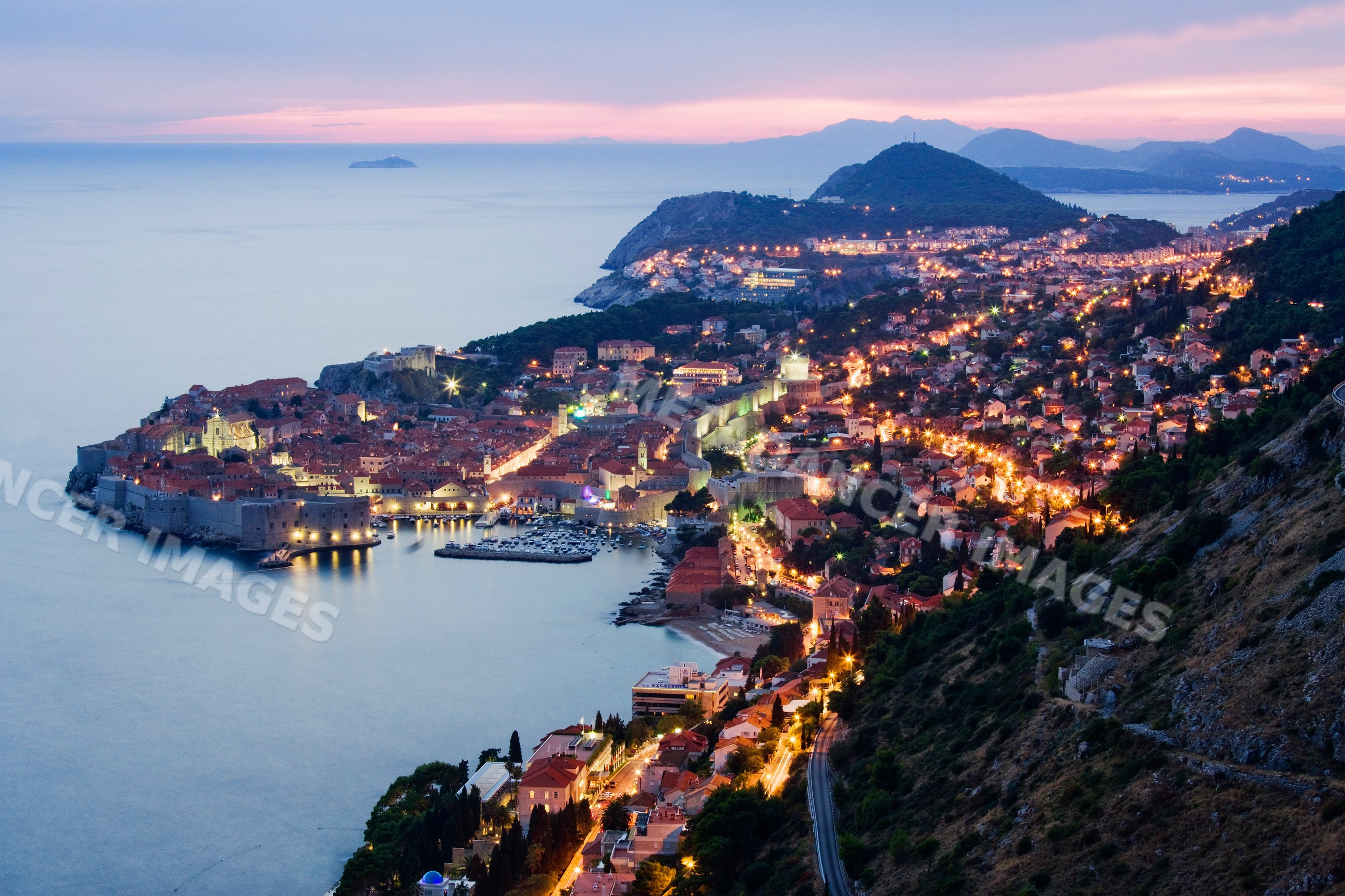 Old city of dubrovnik illuminated at dusk on croatian coastline