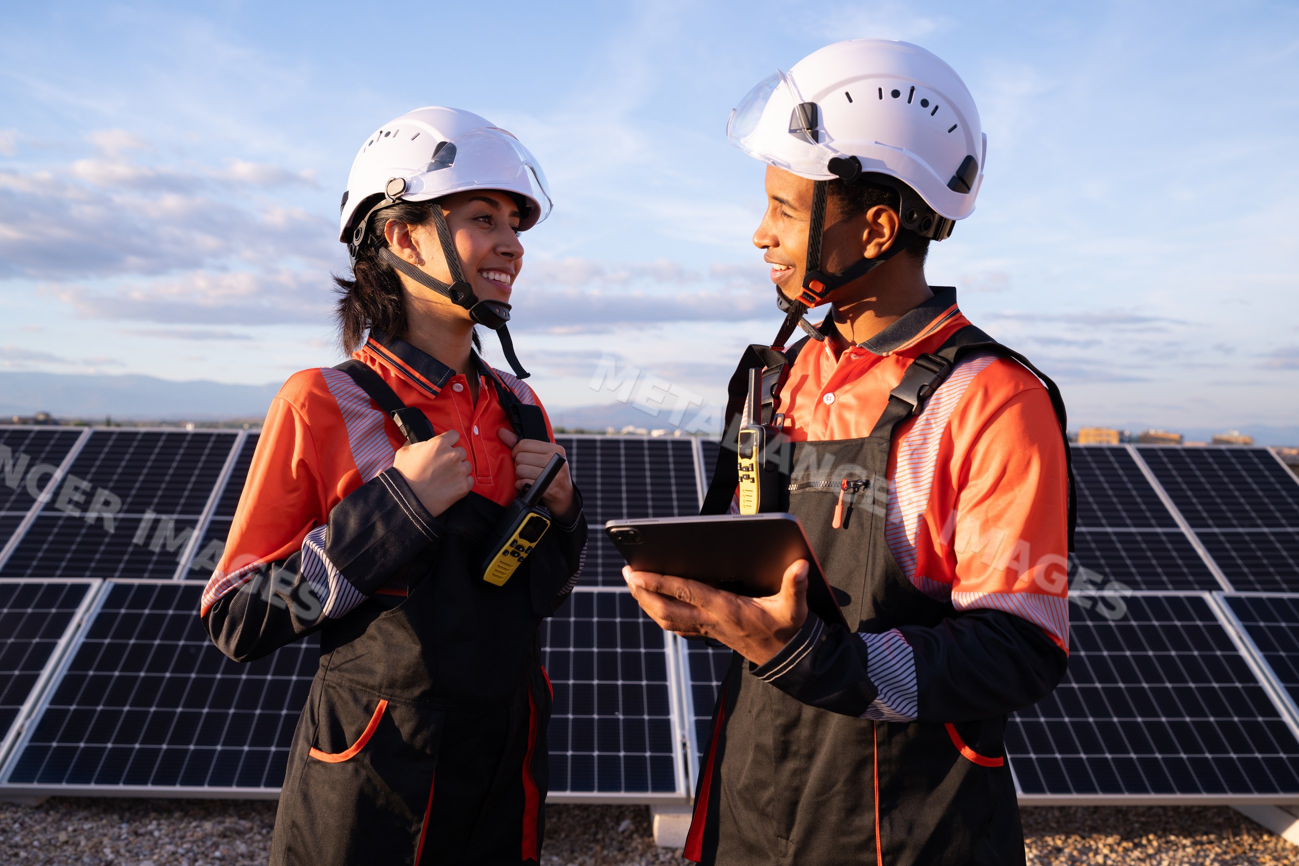 Engineers discussing solar energy production at solar panel array