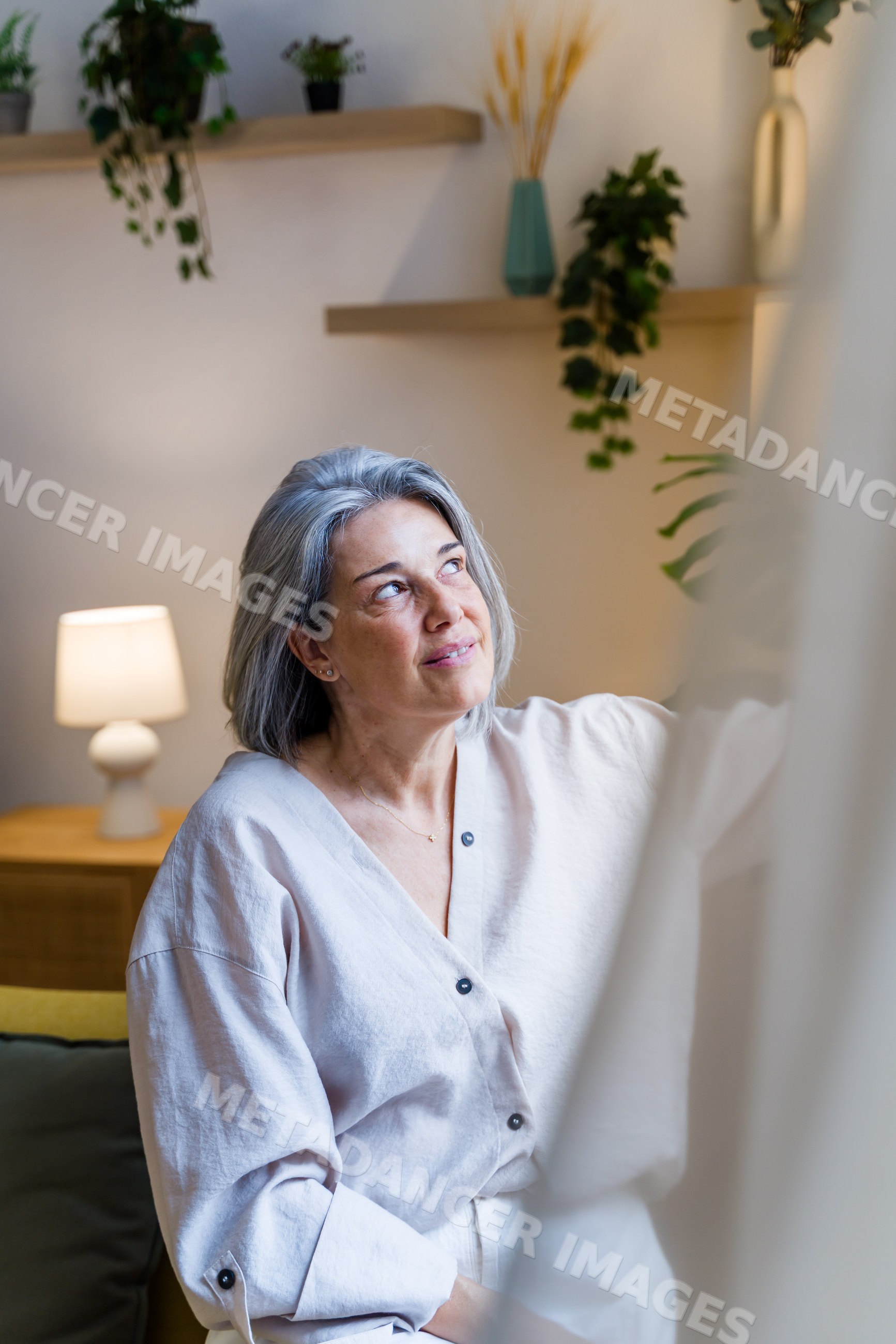 Middle-aged white woman with gray hair looking up in living room
