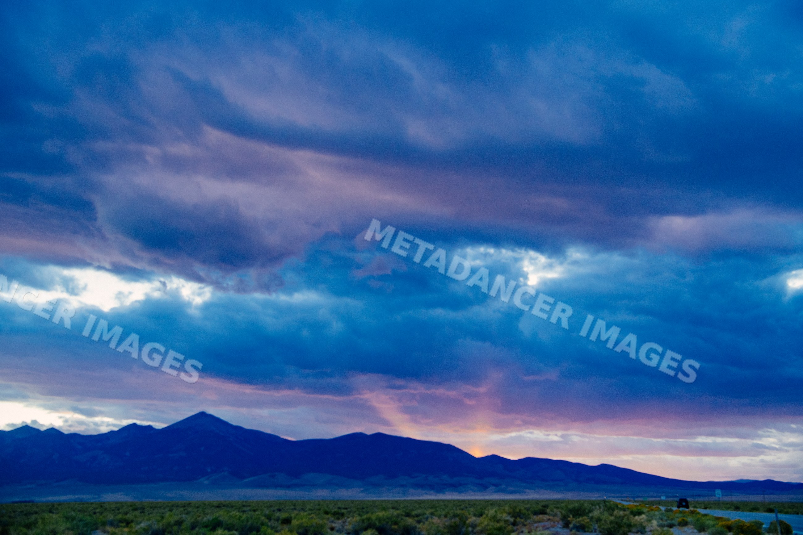 Mountains under colorful sunset sky with dramatic clouds