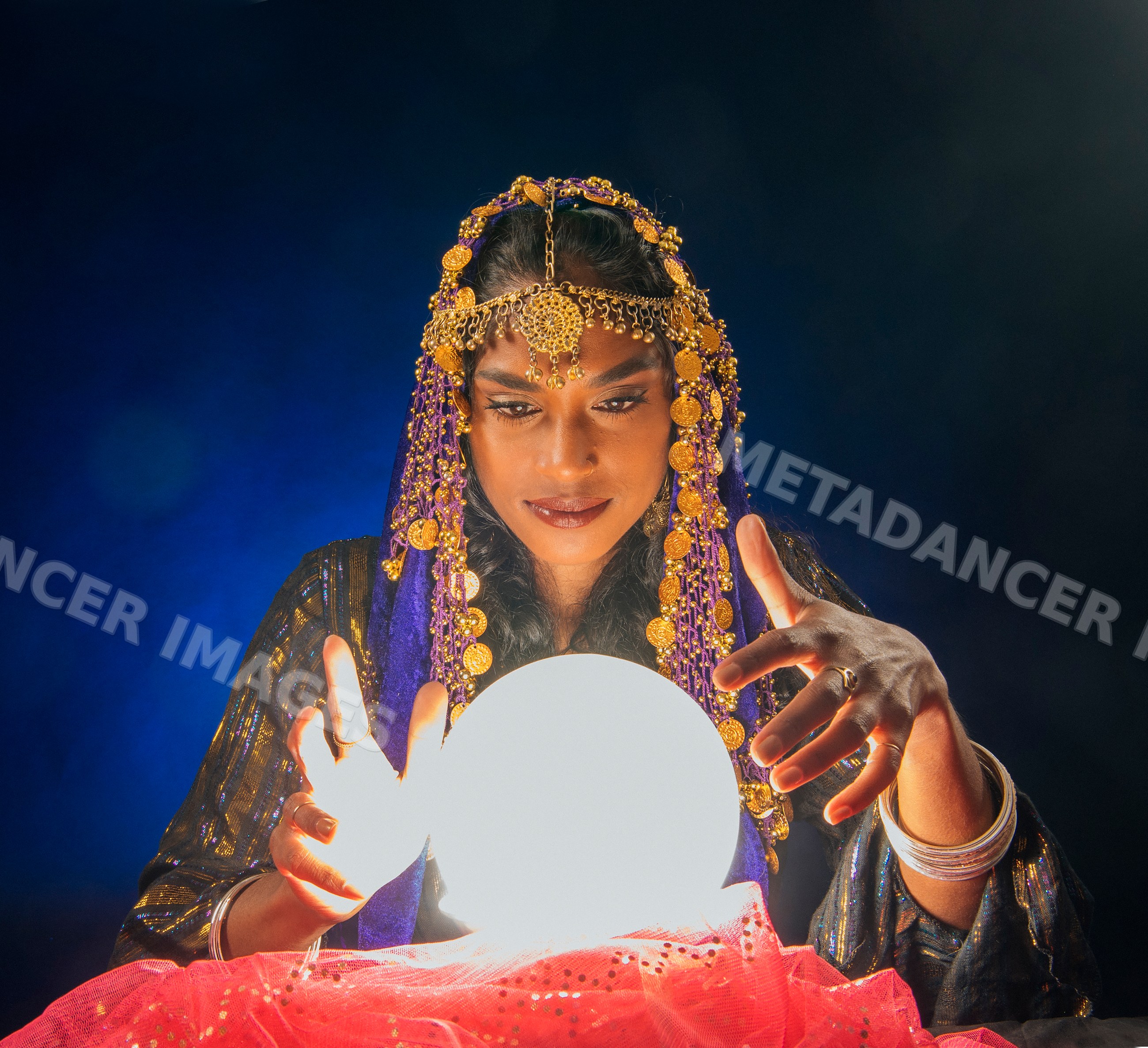 A South Asian woman fortune teller gazes intently