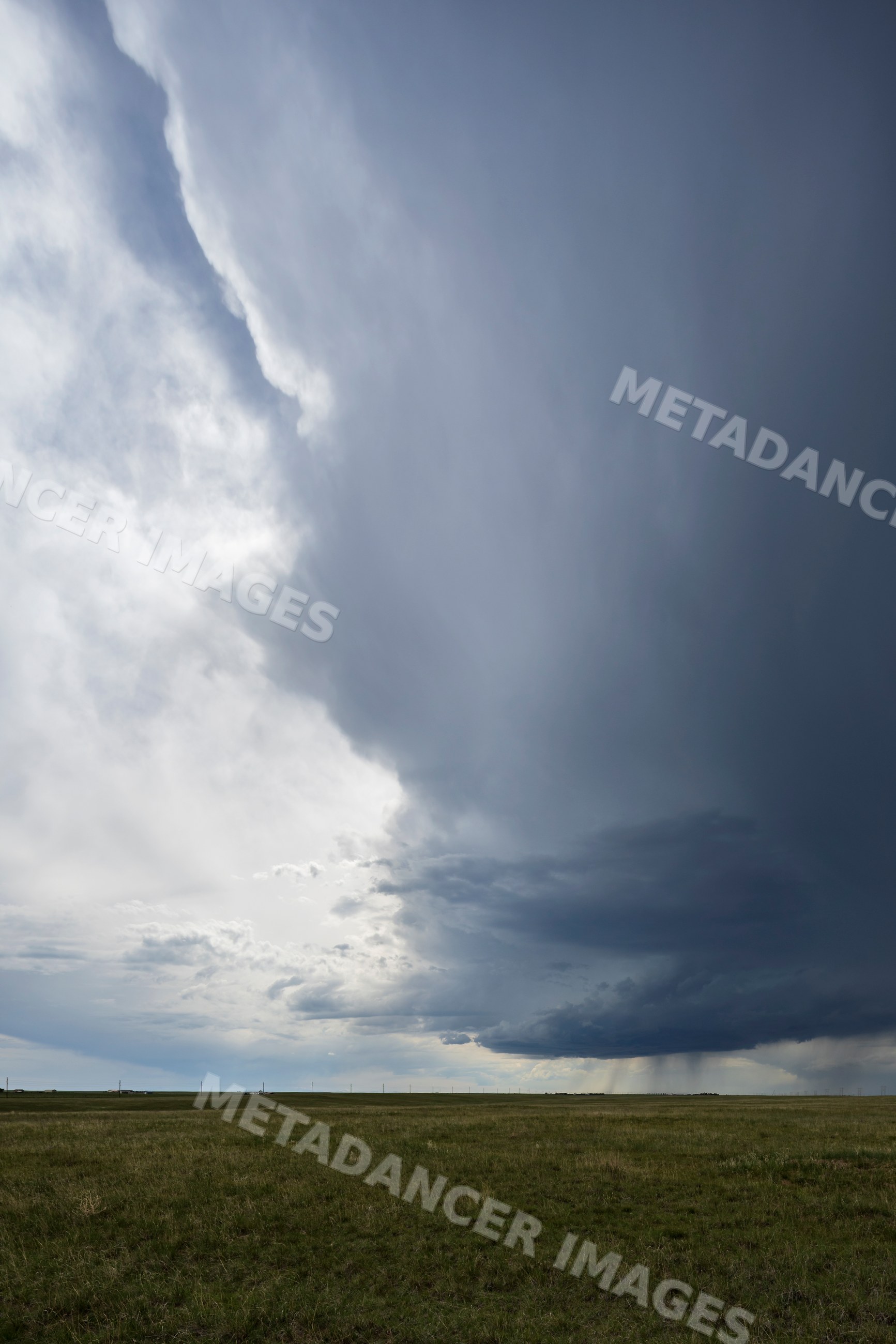 Developing Supercell storm cloud over grass field