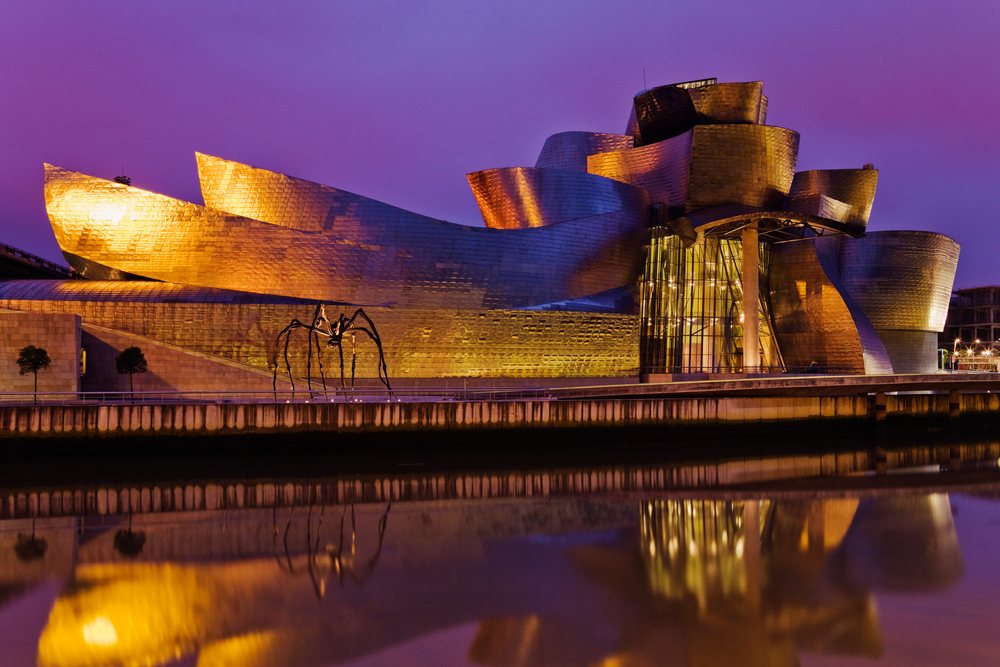 Guggenheim museum reflected in nervion river at night