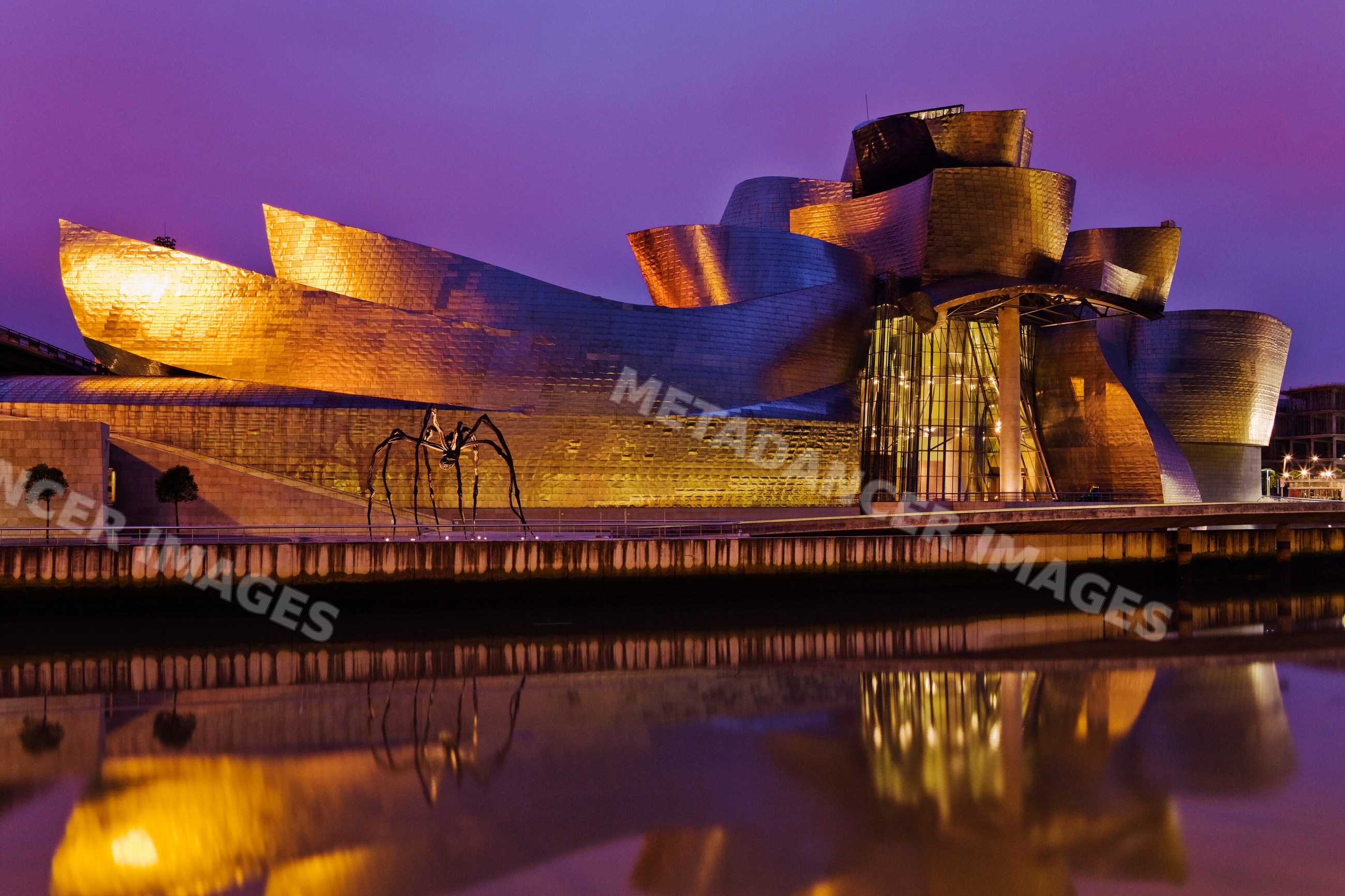 Guggenheim museum reflected in nervion river at night