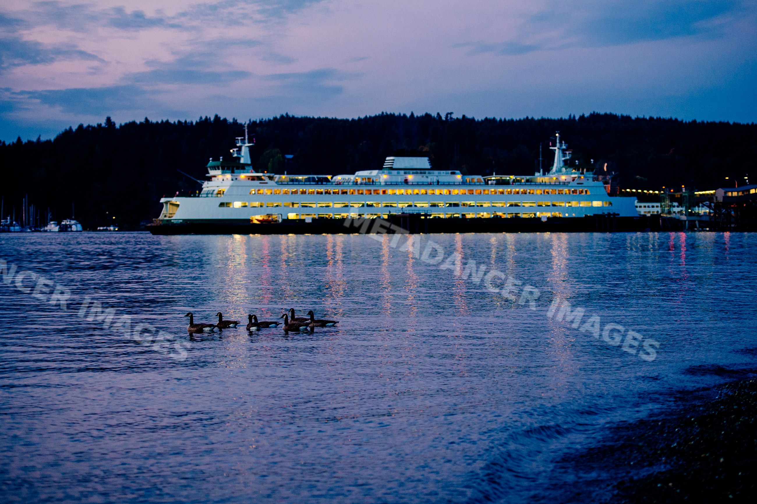 Ferry illuminated at dusk on water near Bainbridge Island