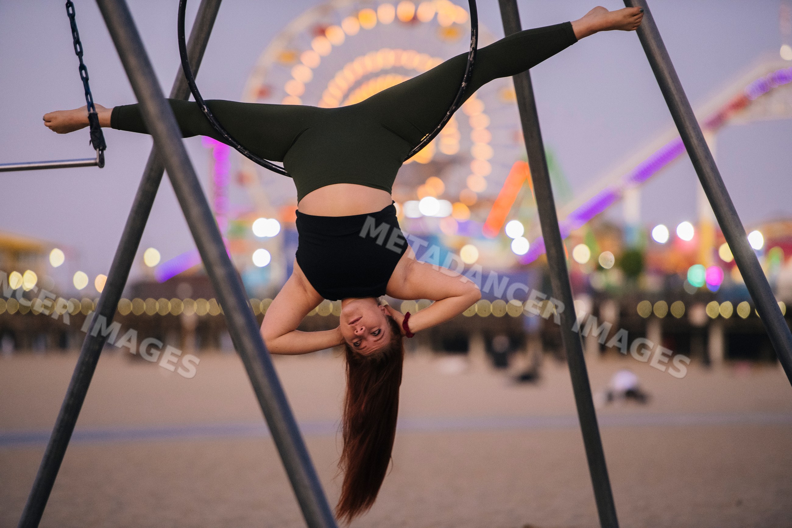 White woman performing inverted aerial hoop pose
