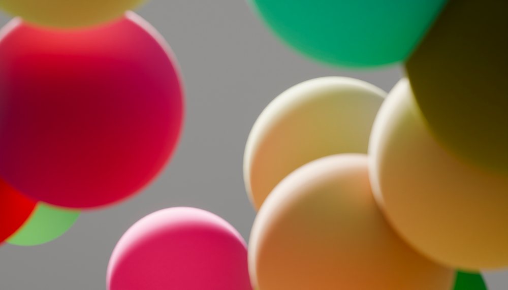 Colorful balloons floating against a gray sky background