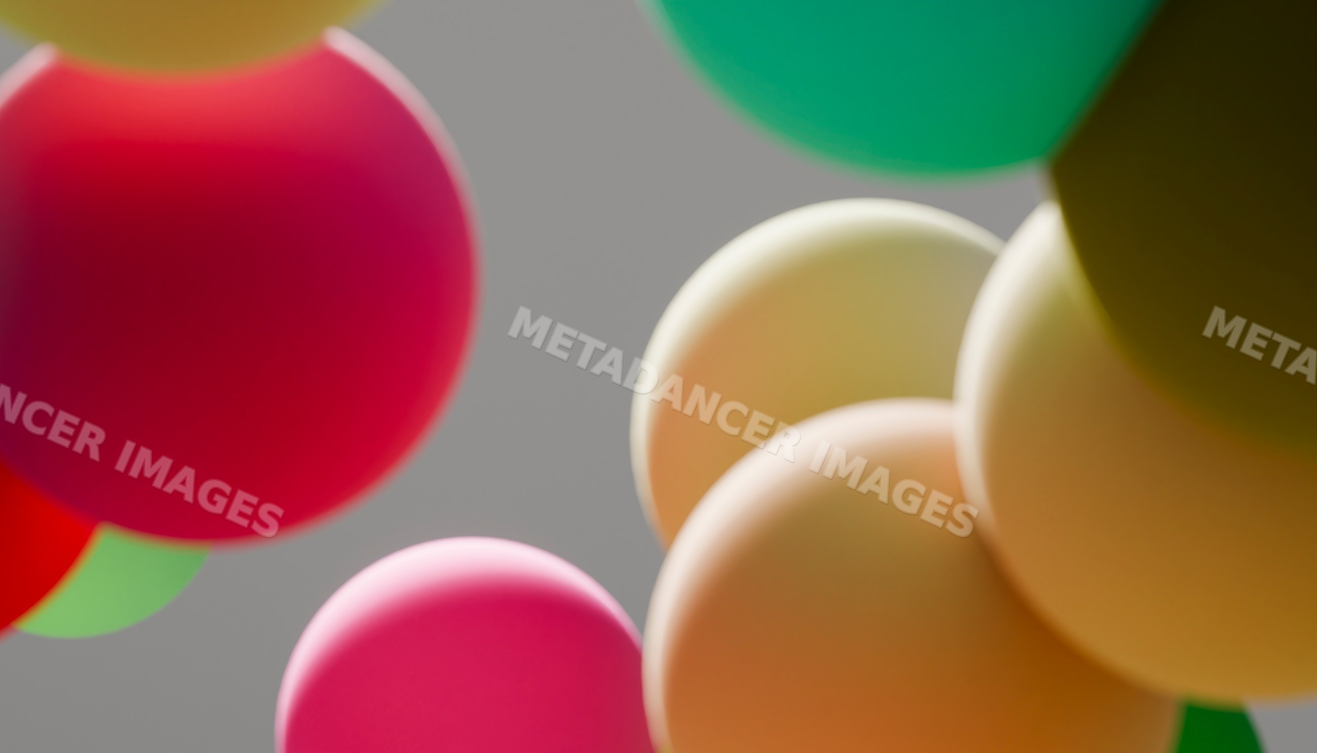 Colorful balloons floating against a gray sky background