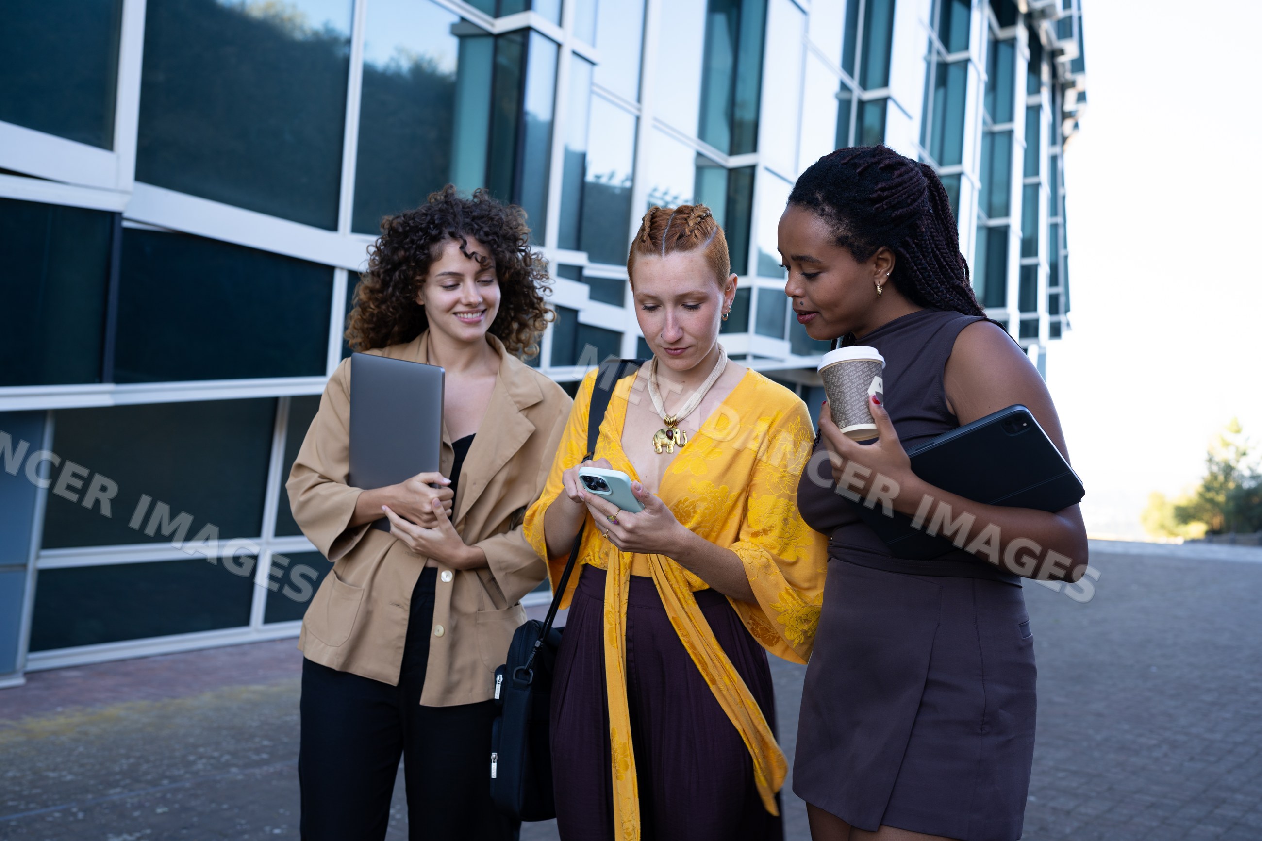 Three African American and white women using smartphone, tablet