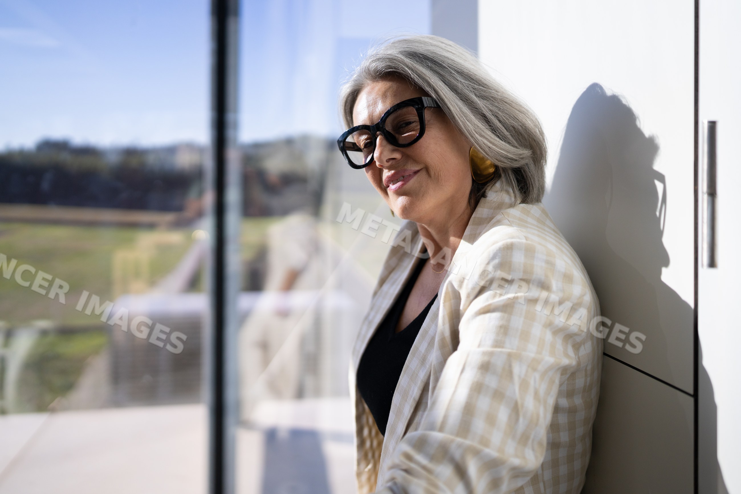 Mature white woman with glasses resting and smiling indoors