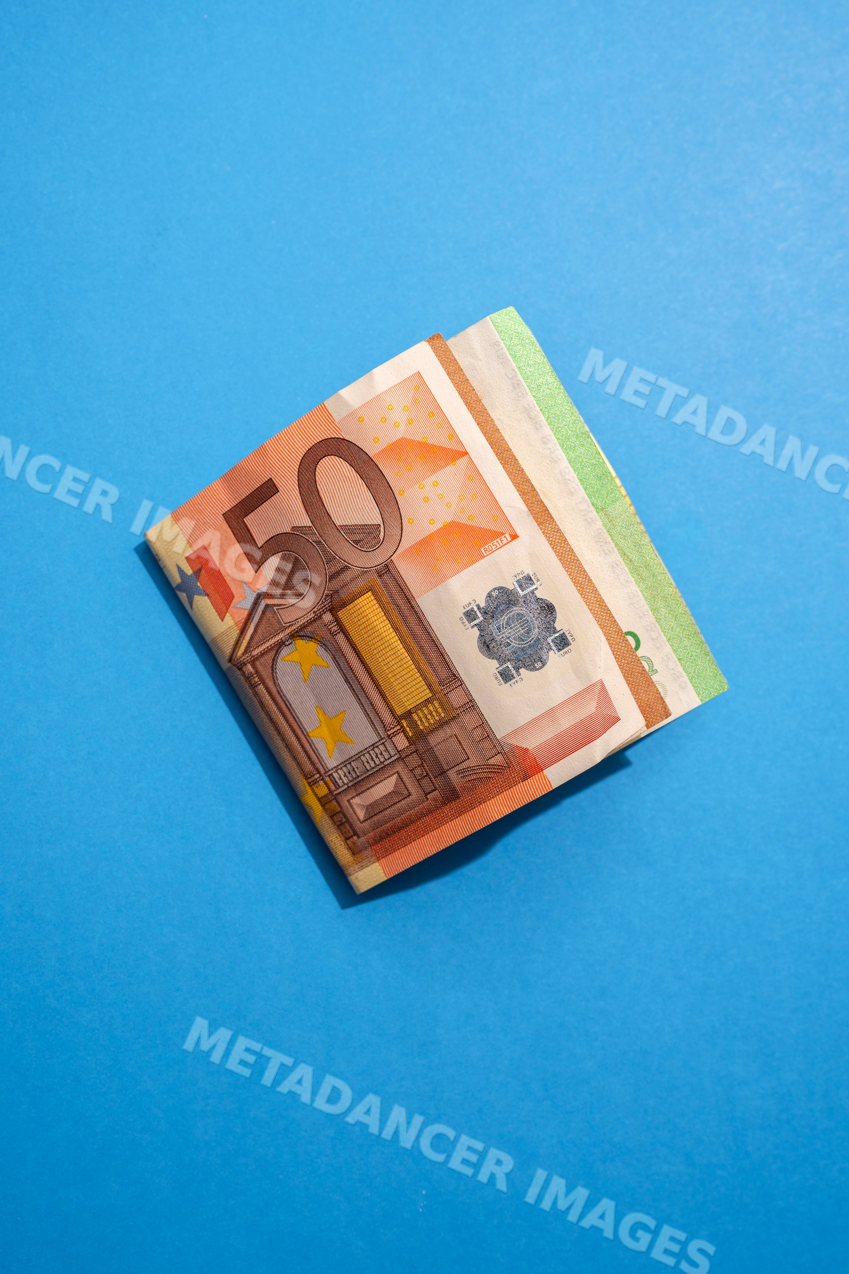 Stack of euro banknotes on blue background