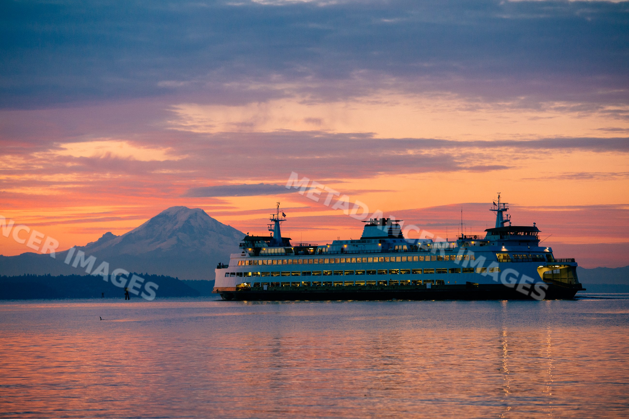 Ferry sailing at sunset with mount rainier in background