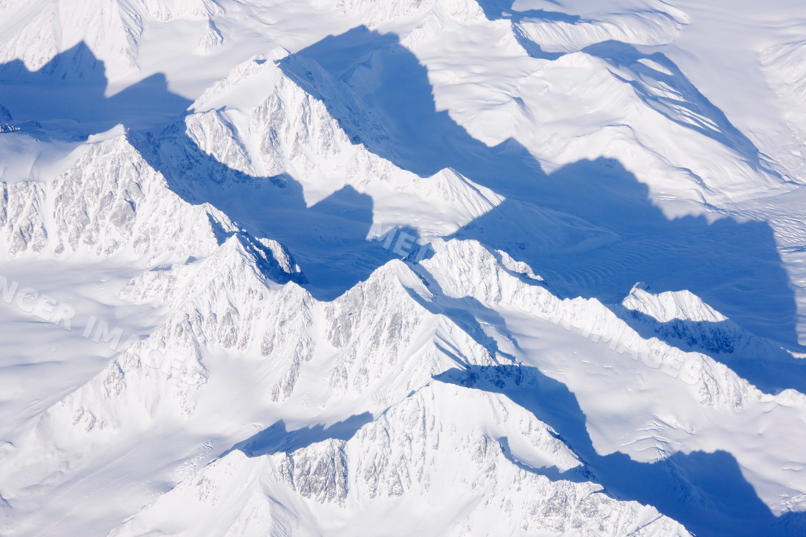 Snow-covered mountain peaks casting shadows wilderness