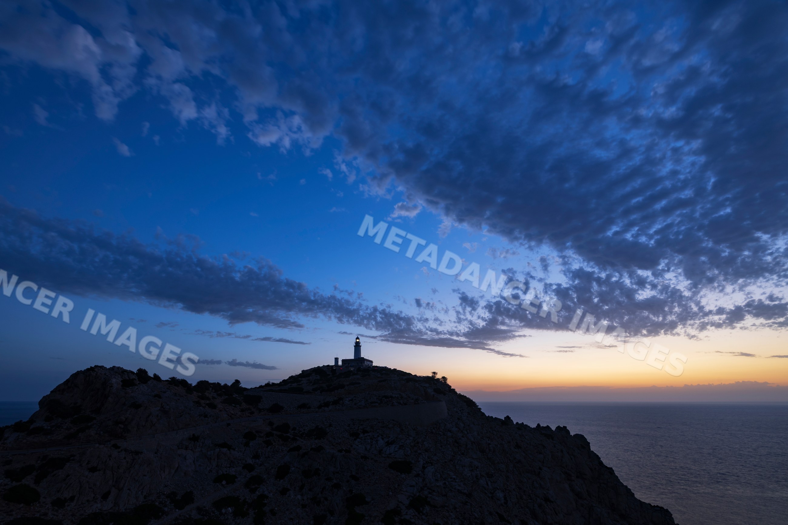 Far de Formentor Lighthouse at sunrise on rocky cliff