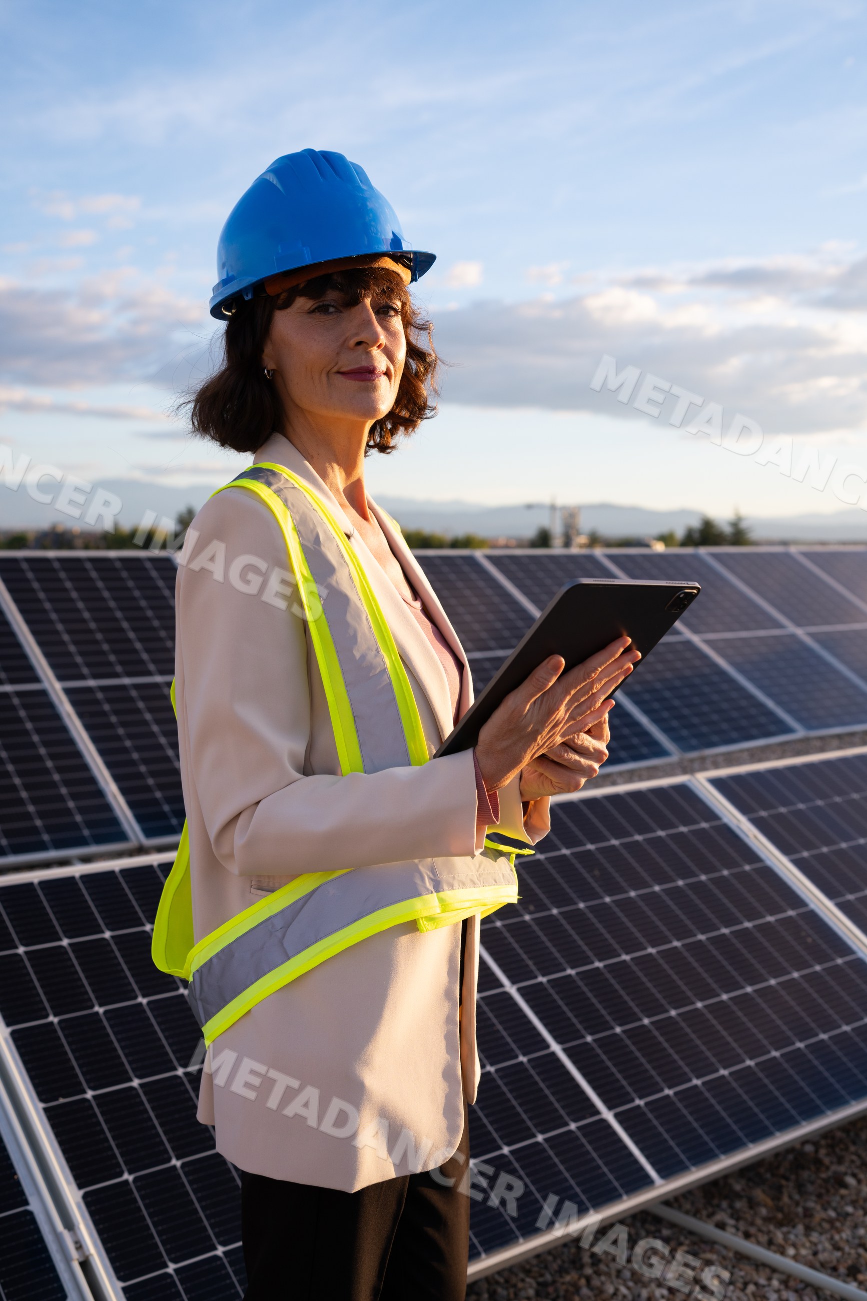 White woman engineer inspecting solar panels