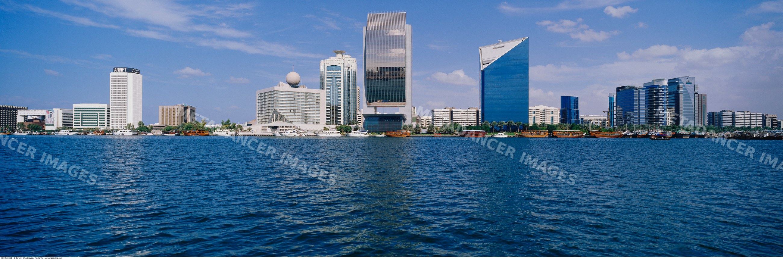 Dubai creek skyline with modern buildings and boats on waterfront