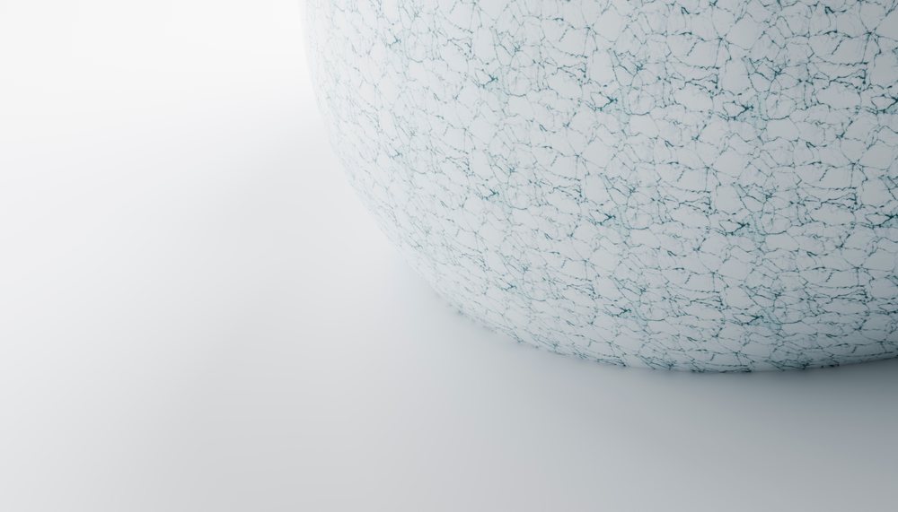 A white sphere with cracked texture on a smooth surface