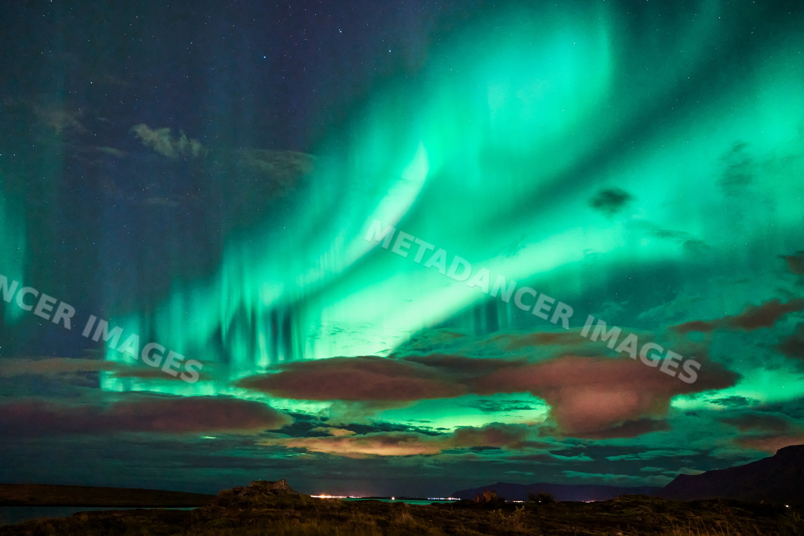 The northern lights illuminate the night sky over Iceland's landscape