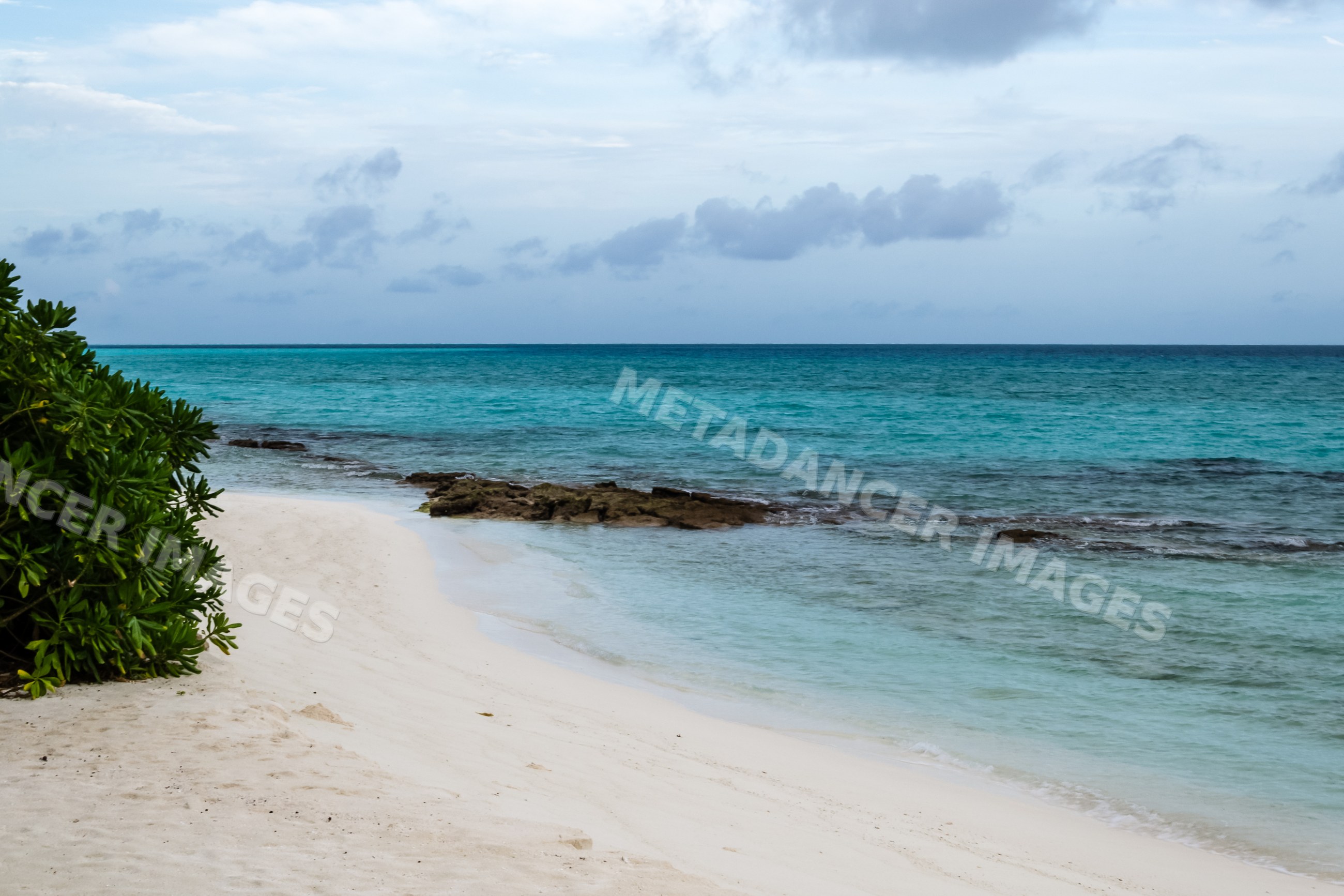 Beach shoreline with turquoise water and rock formation in a beach