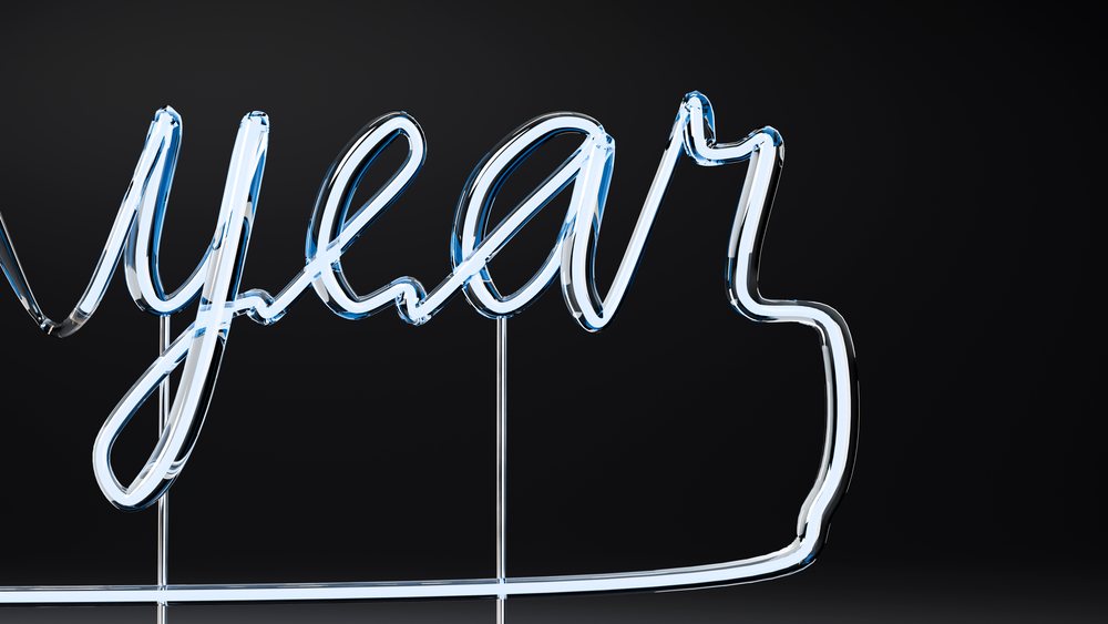 Glowing neon light sign spelling year on black background