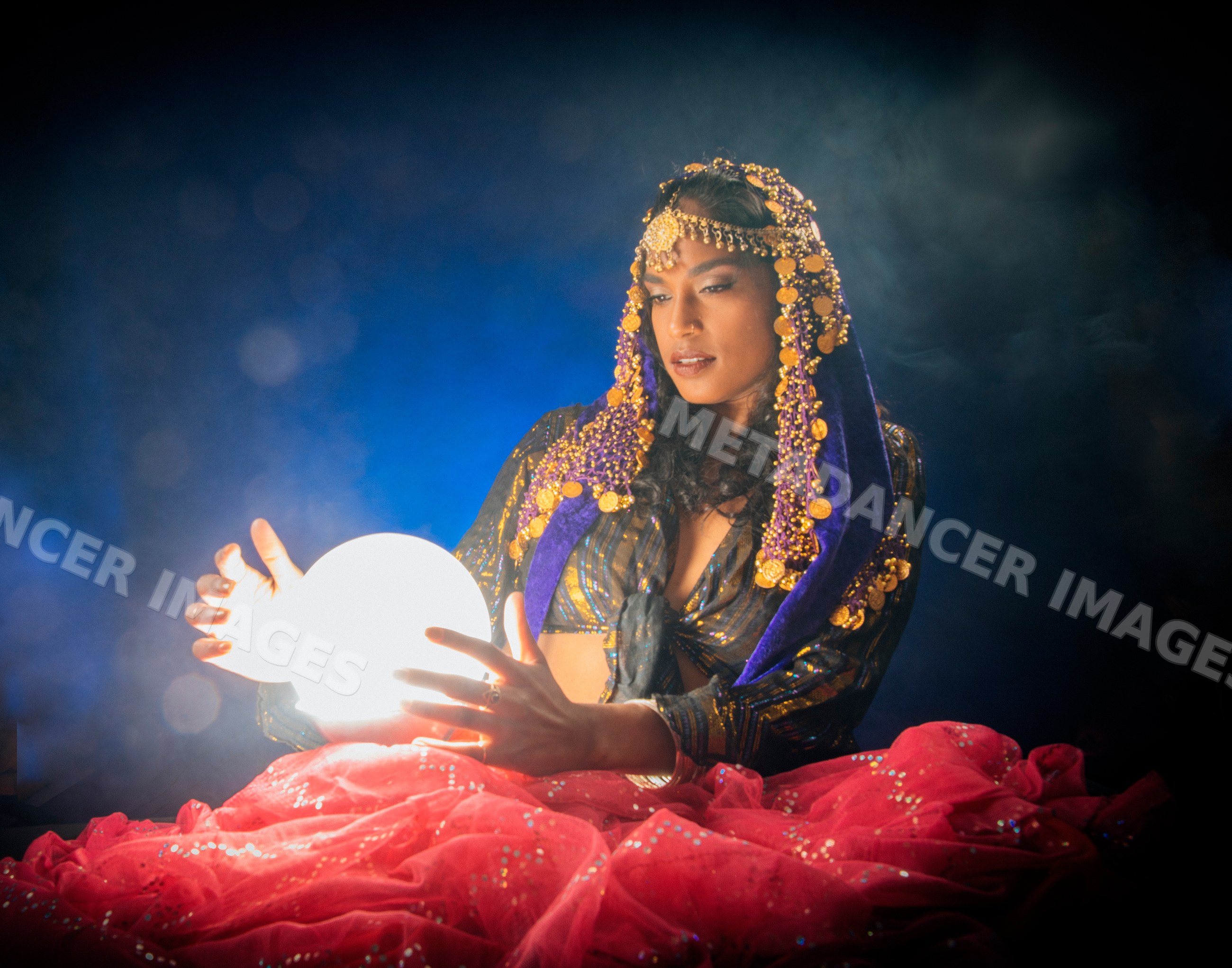 A South Asian woman holds a glowing orb for fortune telling