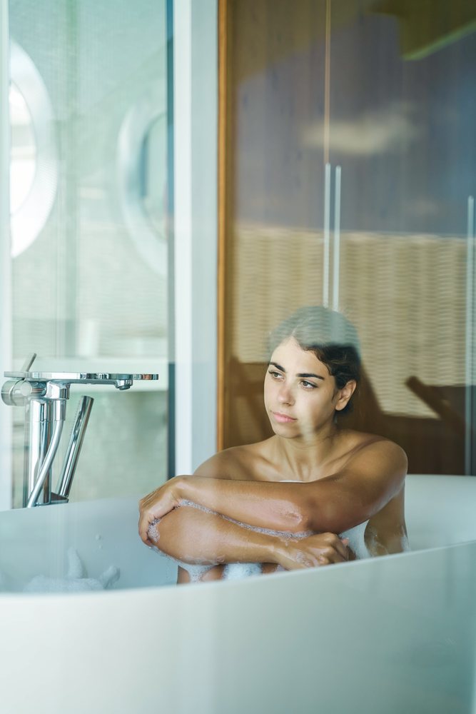 A white woman relaxing in a bathtub during a bubble bath