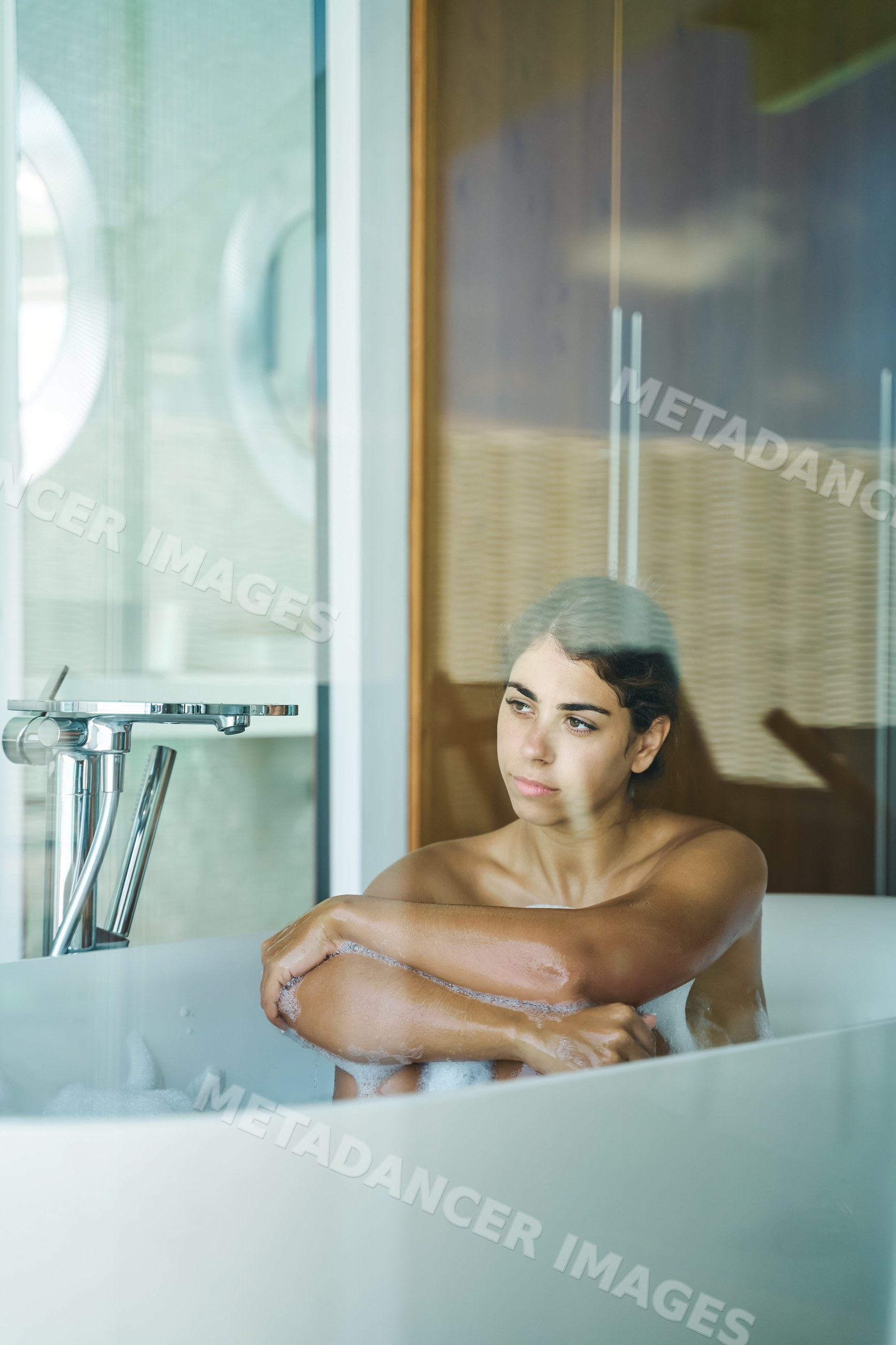 A white woman relaxing in a bathtub during a bubble bath