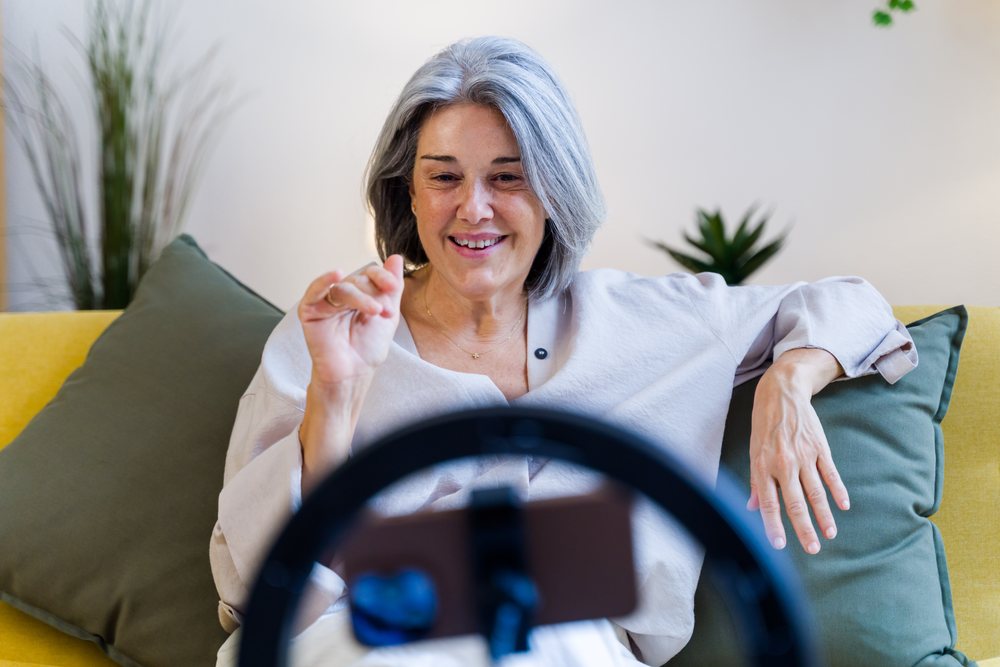 Mature white woman video chatting on smartphone with ring light
