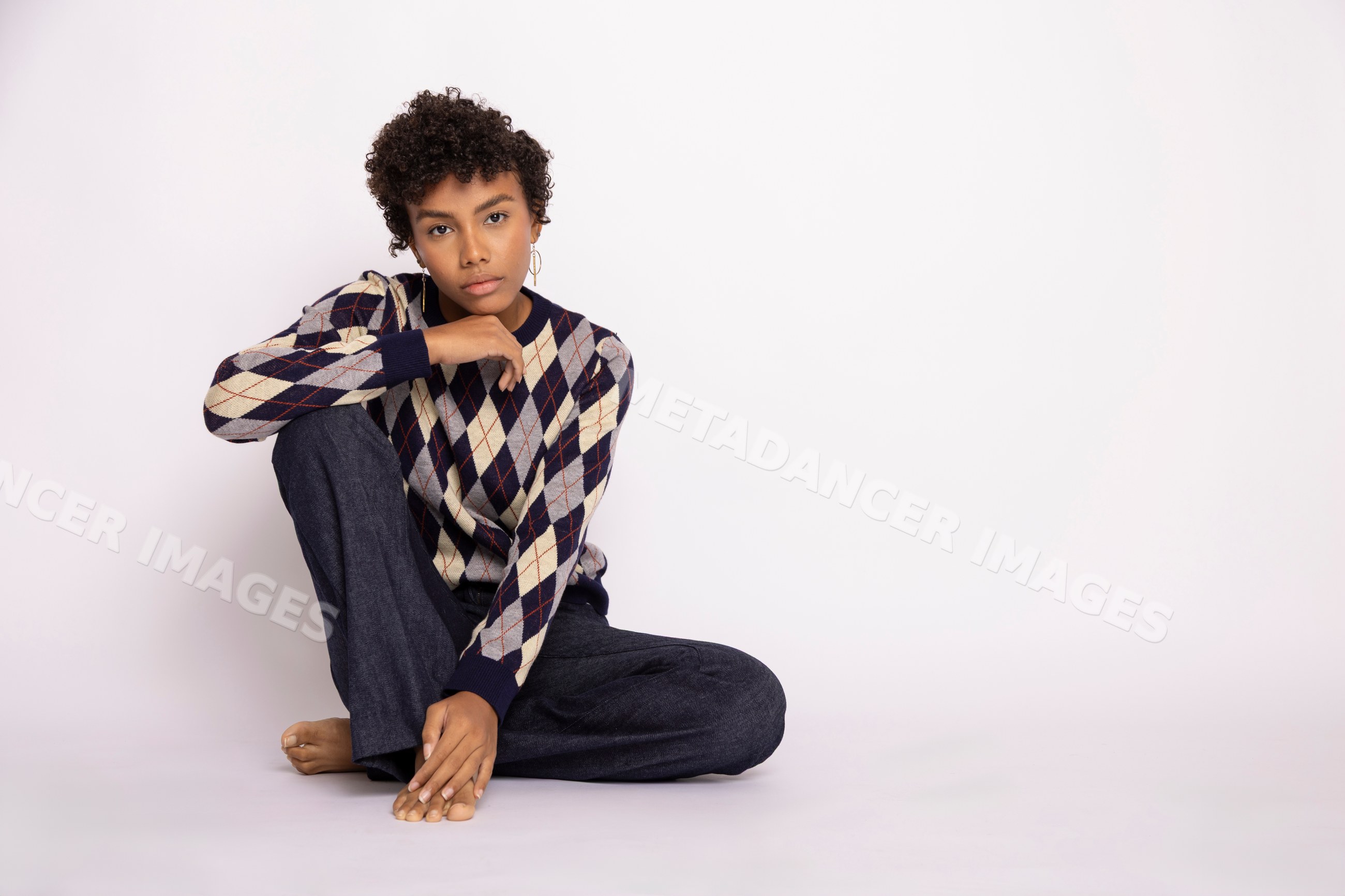 Young Hispanic woman posing thoughtfully in argyle sweater
