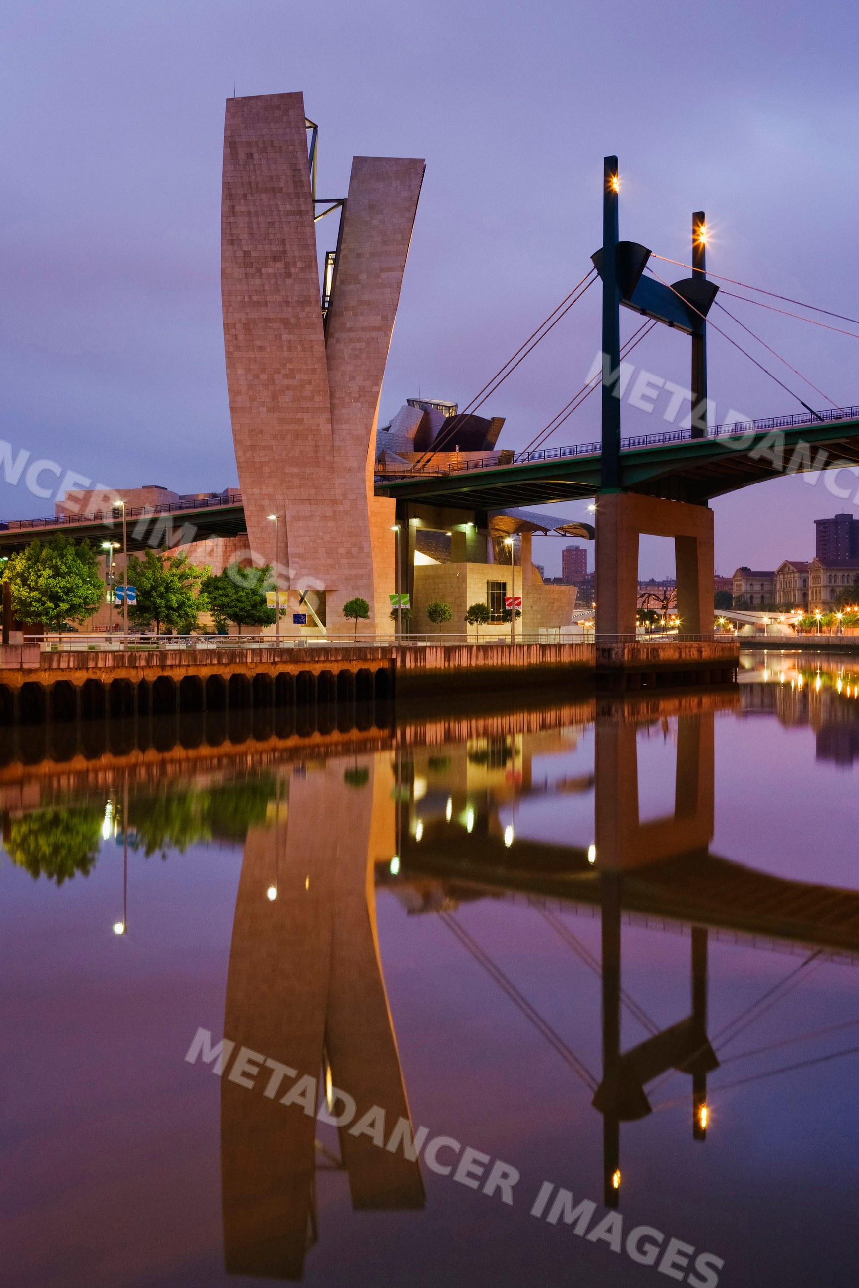 Guggenheim museum bilbao and bridge reflecting in the river at dusk