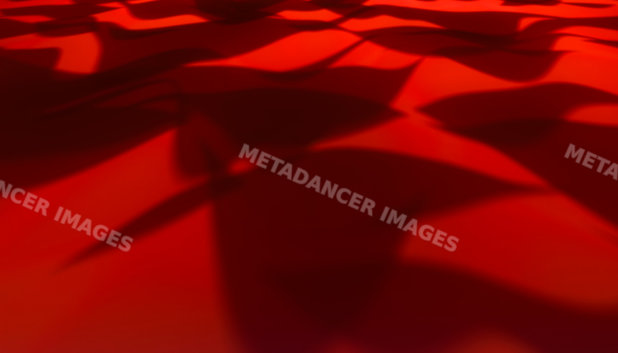 Red fabric with flowing folds and shadow patterns close-up