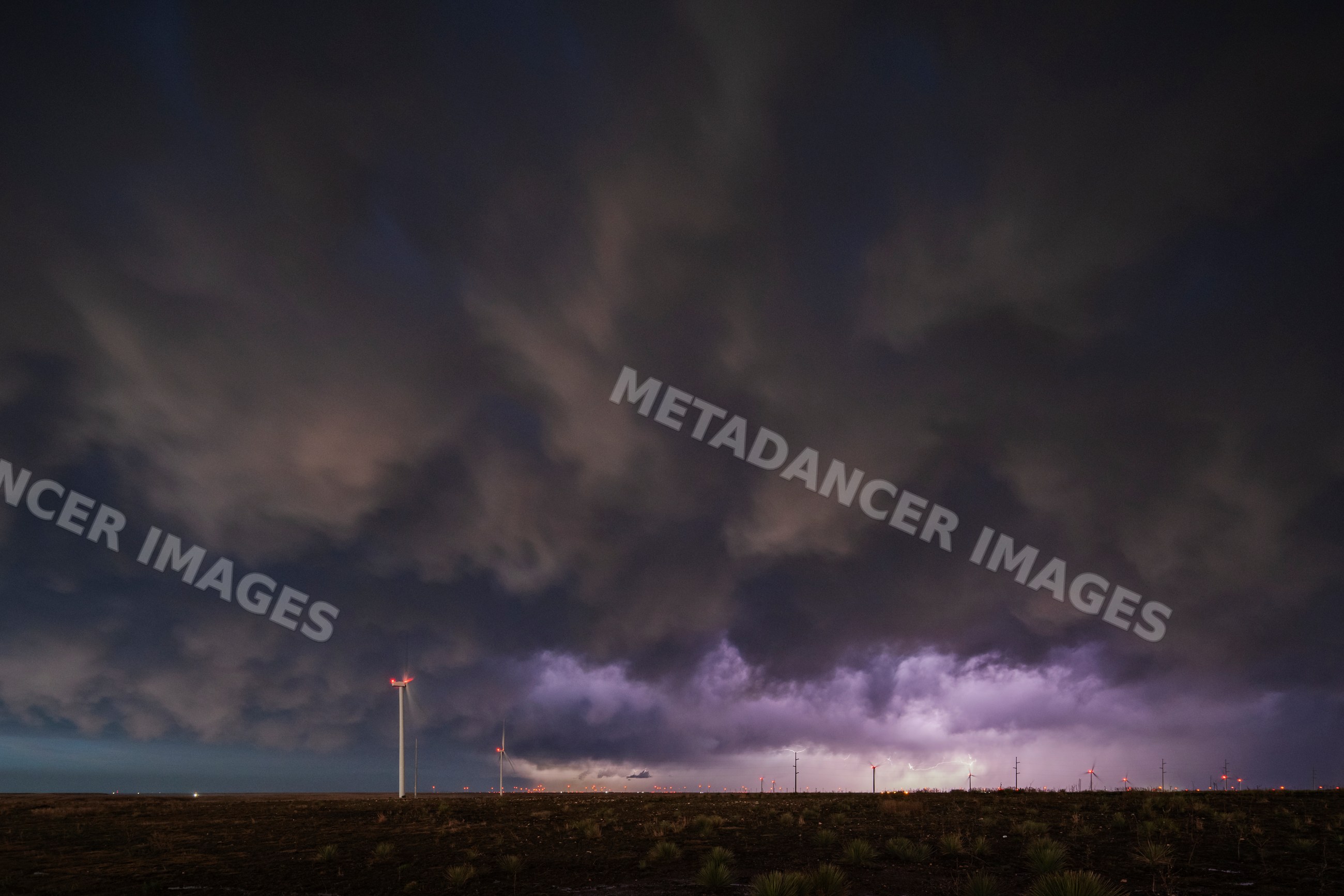 Lightning over wind turbines during storm receding