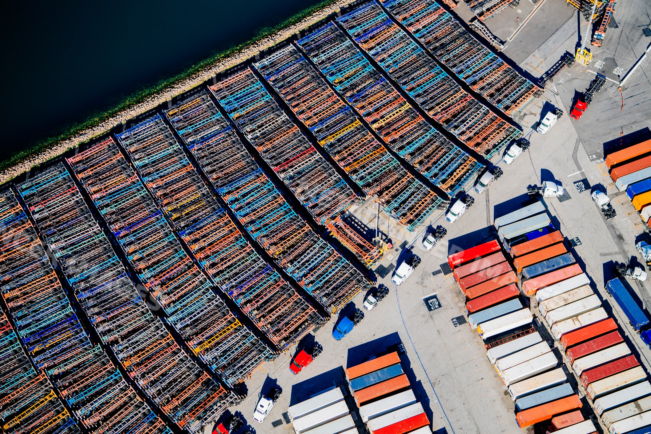 Container trucks and shipping containers at a terminal in a beach