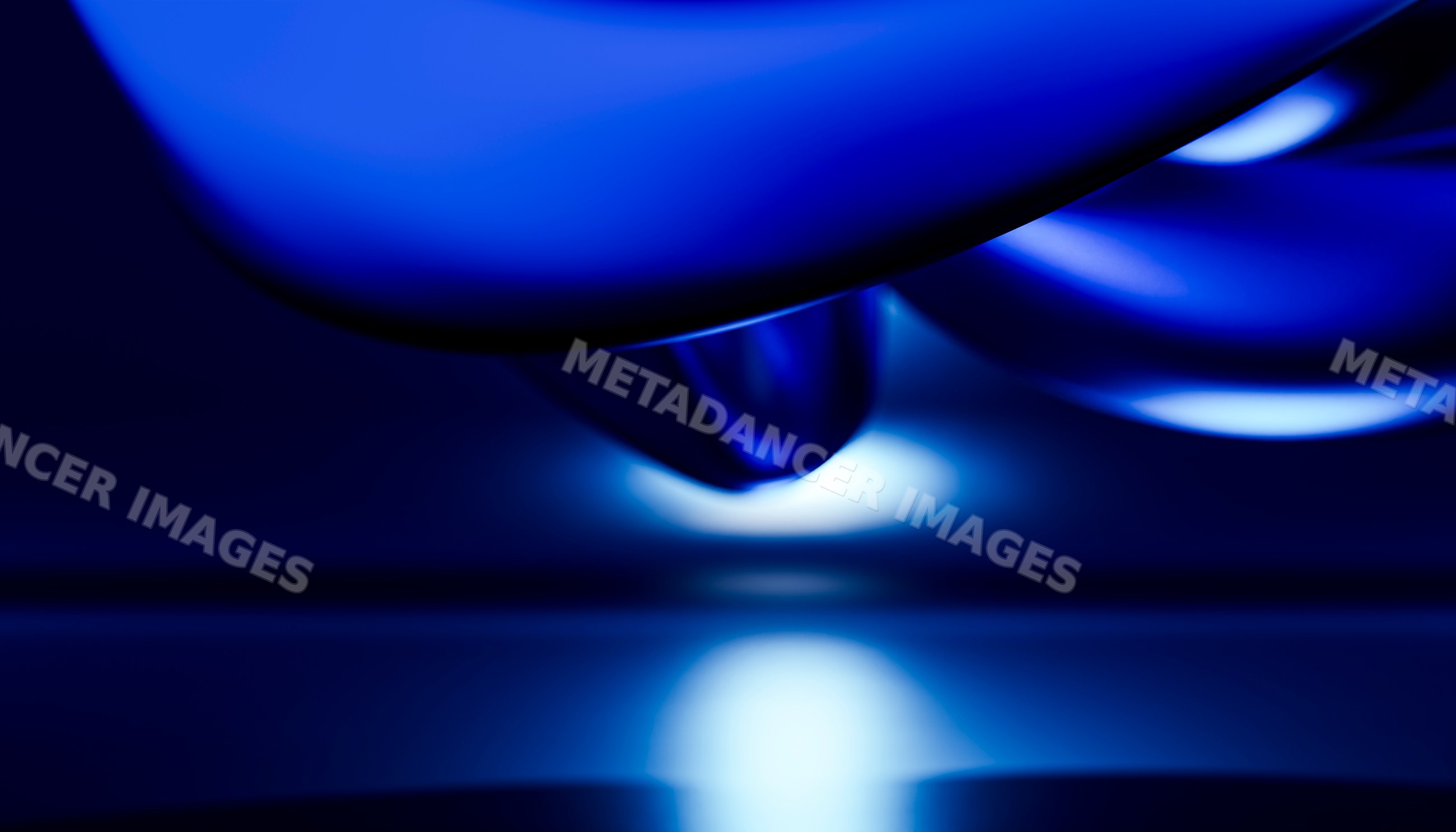 Close-up of glossy blue object with illuminated reflection