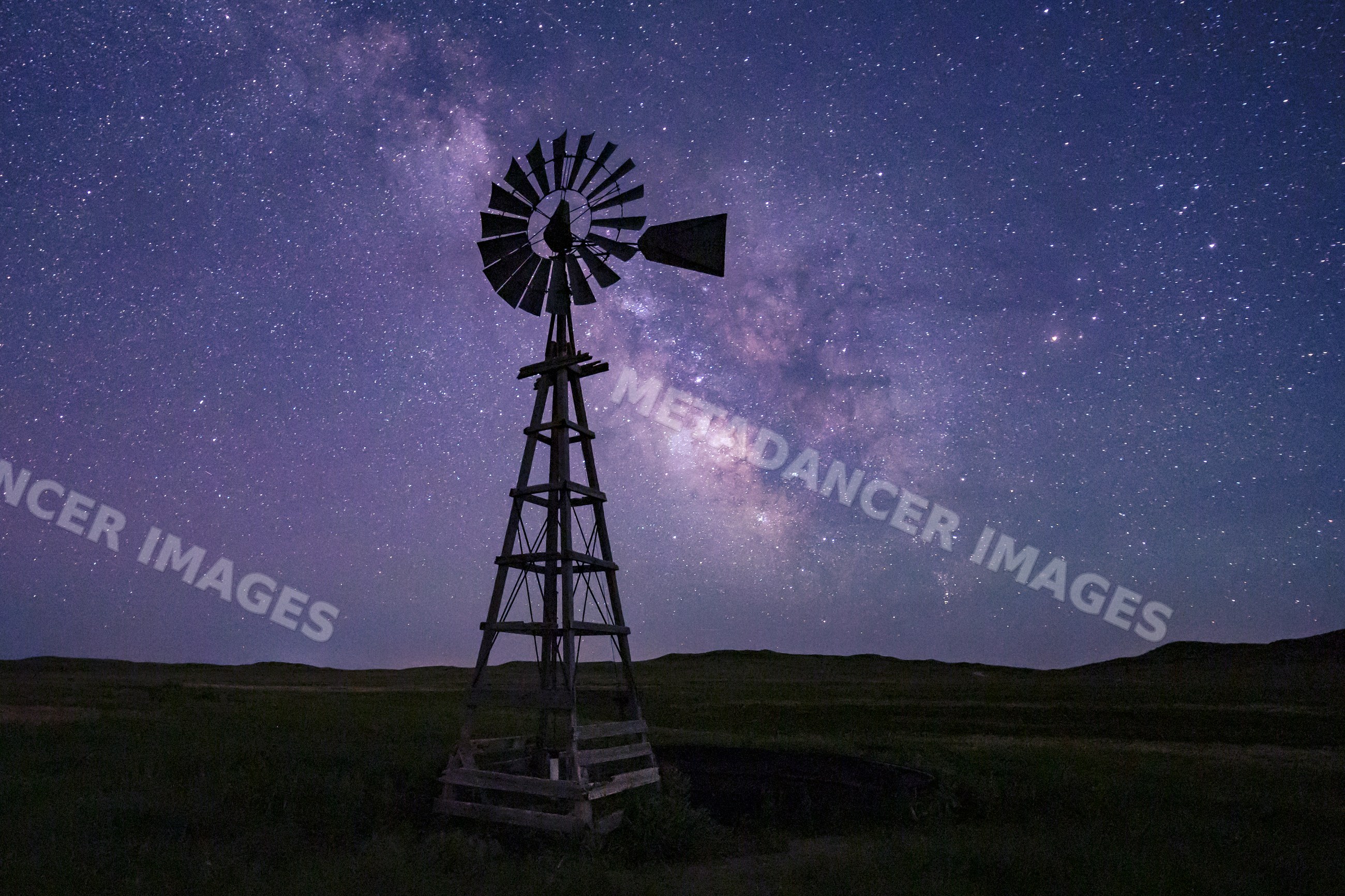 Windmill under Milky Way night sky in Nebraska Great Plains