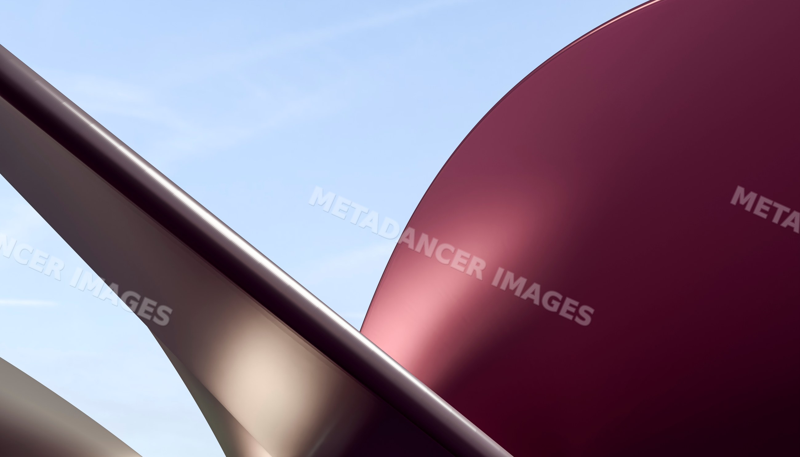 Curved metal sculpture with red and beige surfaces against sky