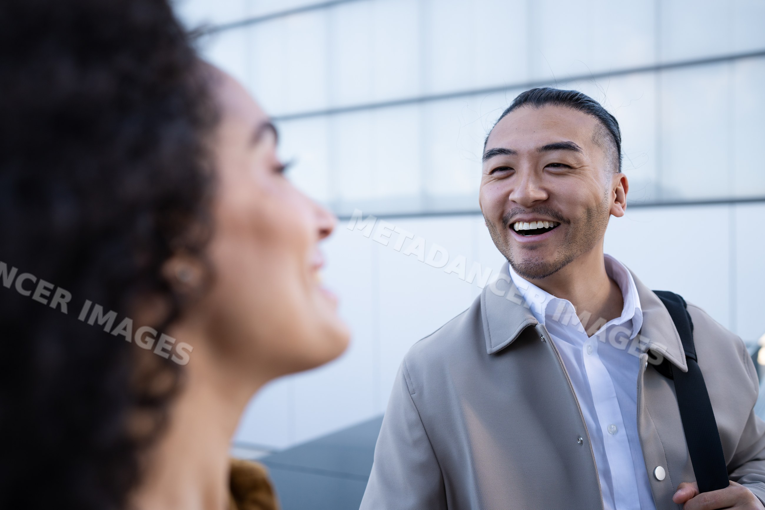 Man smiling and talking with woman outdoors in urban setting in Madrid