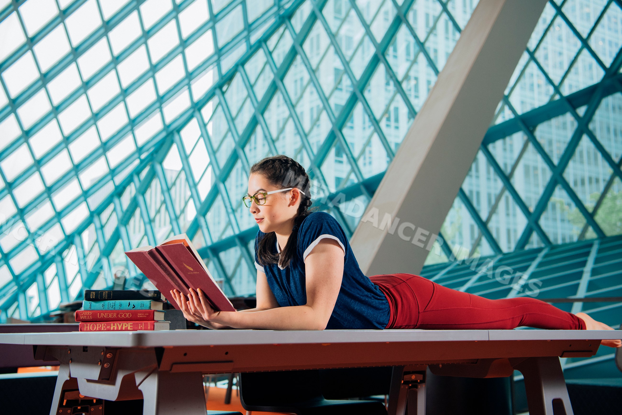 Woman reading book inside a modern public library in a library