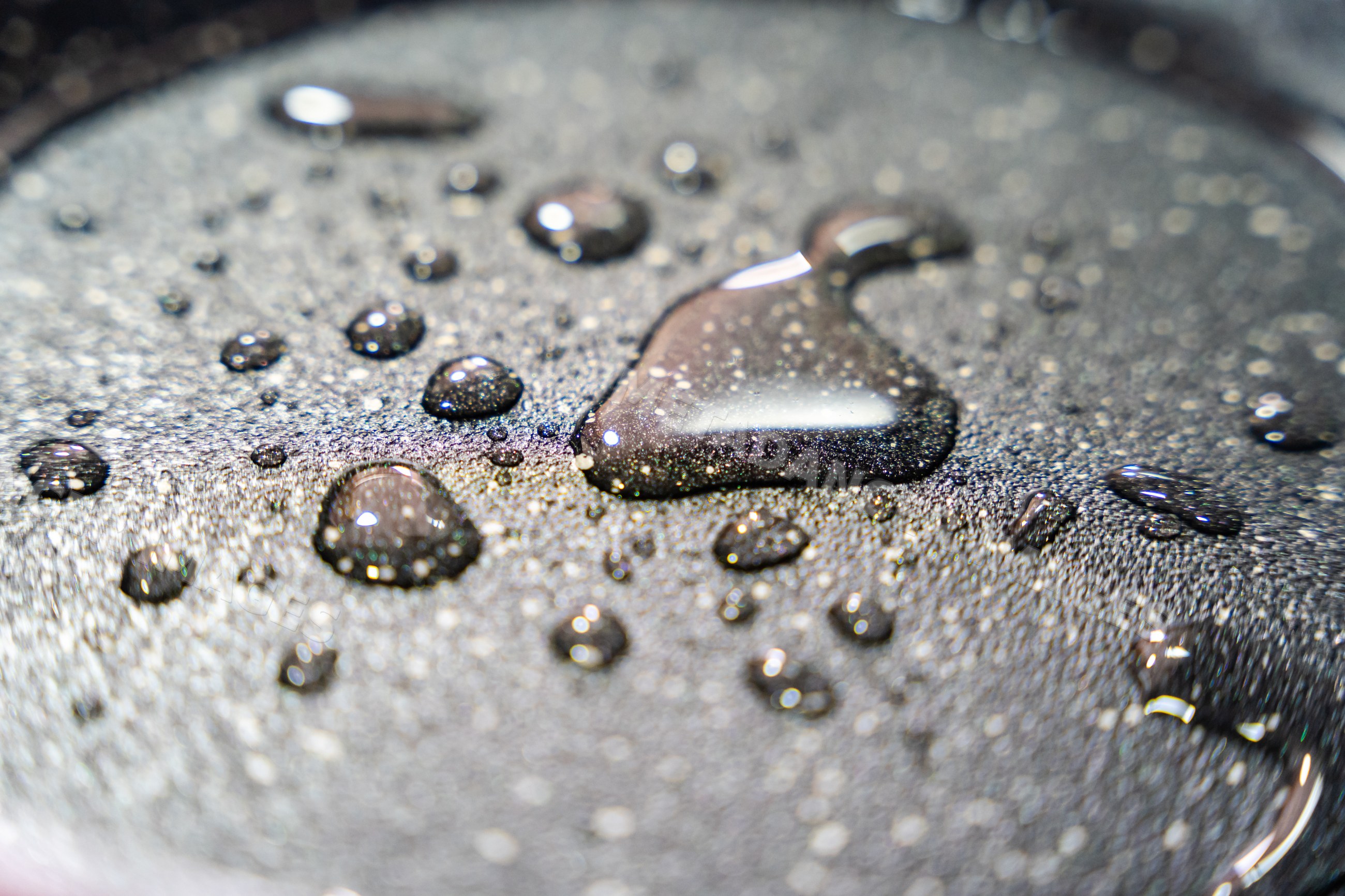Close up of water droplets on textured metal surface