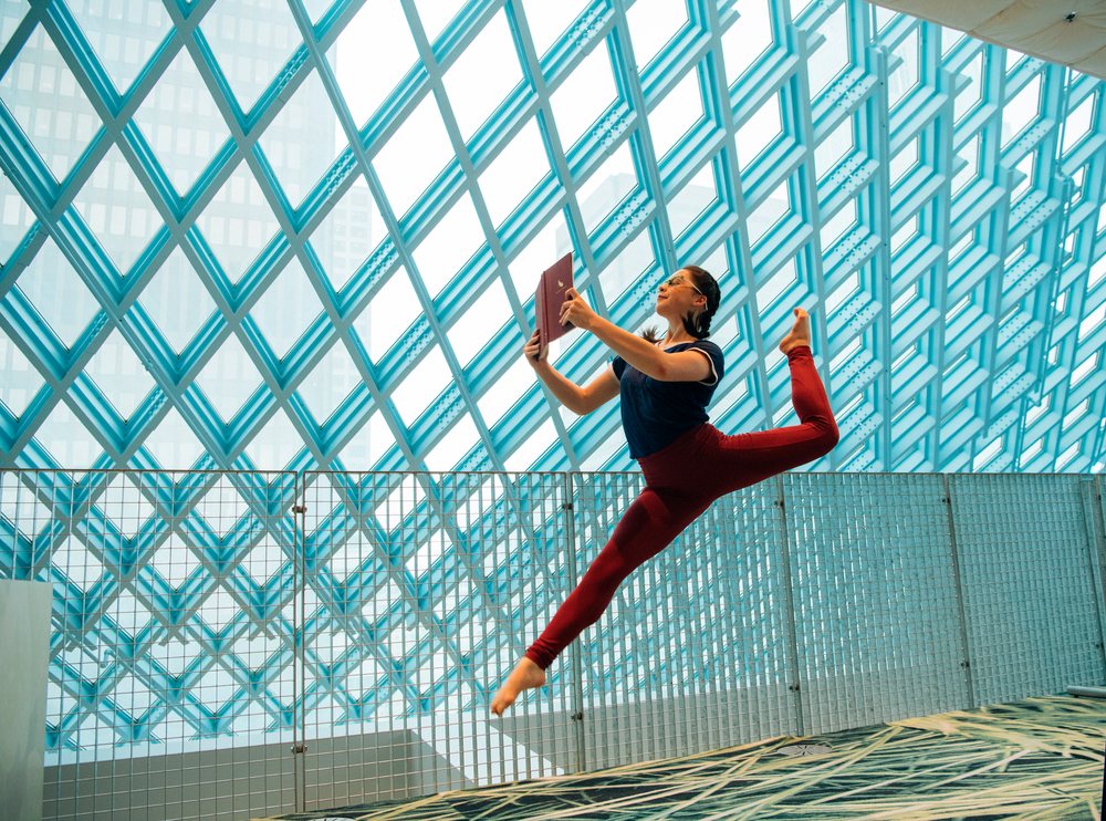 A woman jumps while reading a book inside the Seattle public library