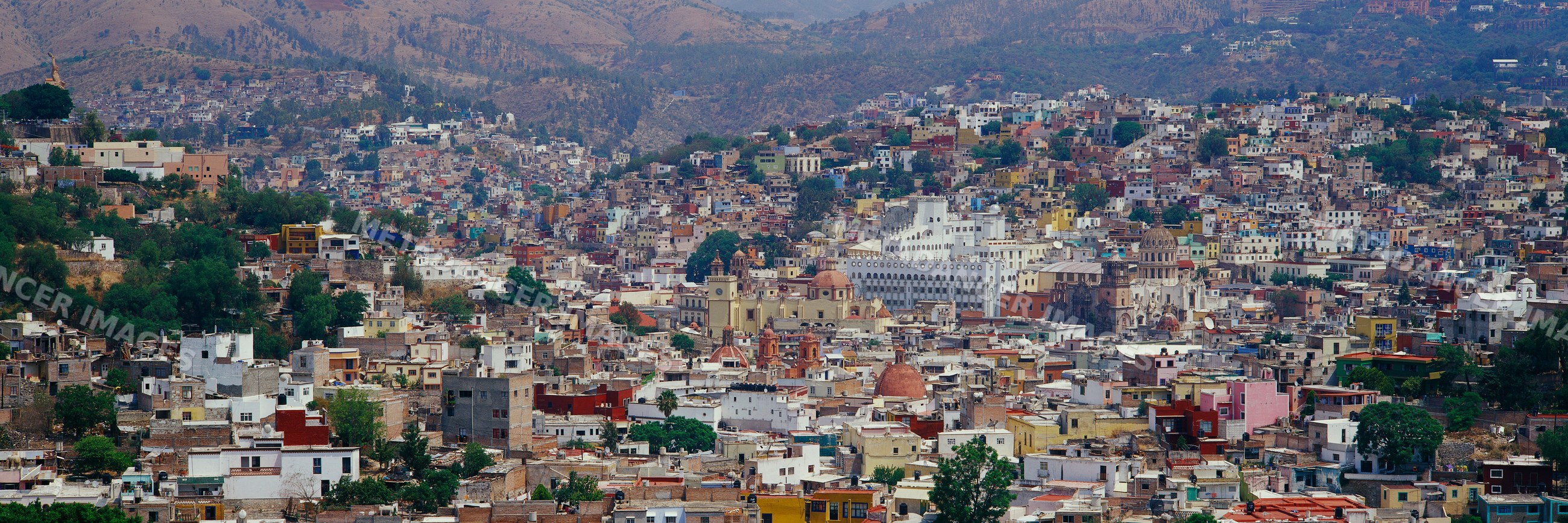Colorful hillside cityscape with mountainous background