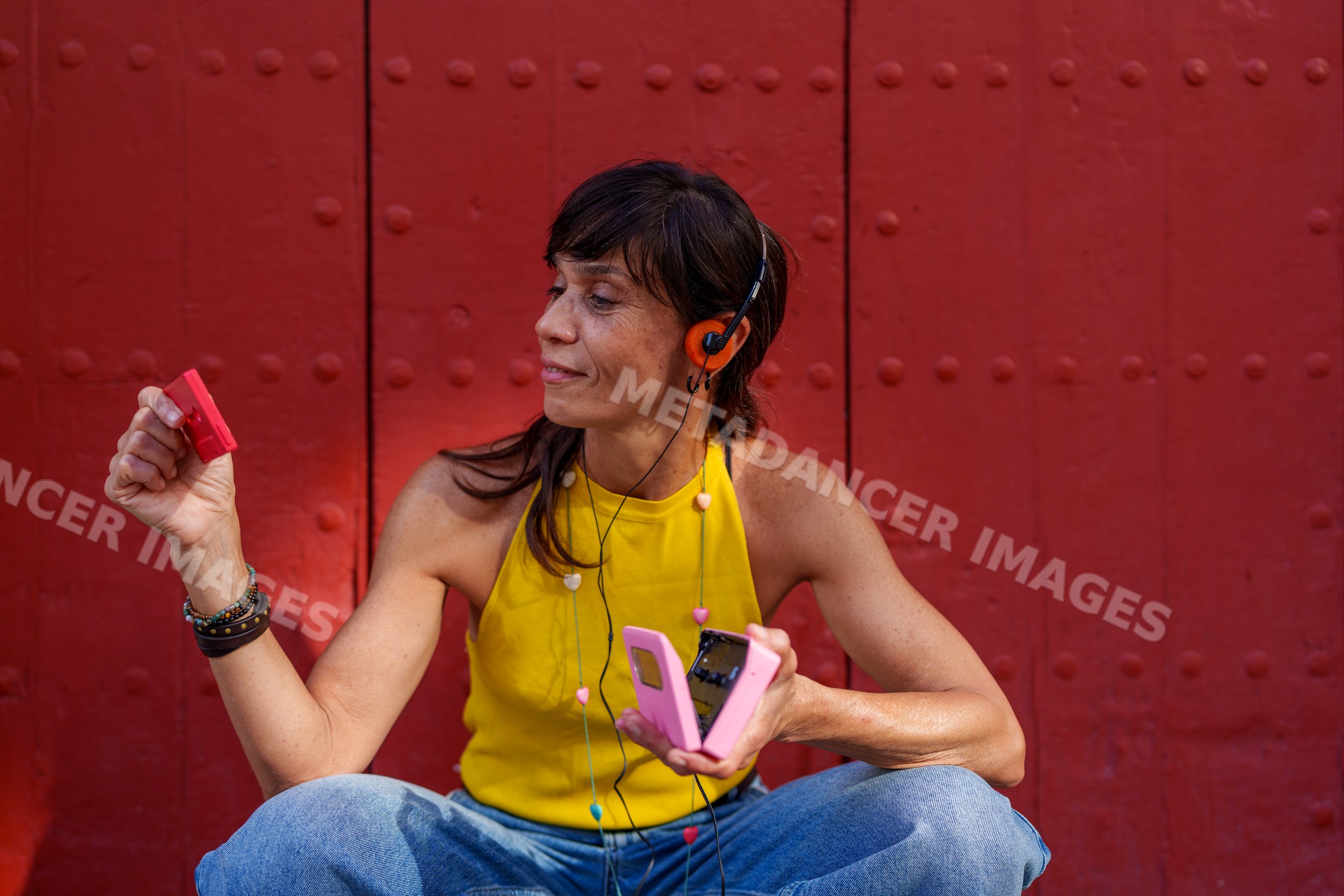 Hispanic woman listening to music outdoors with headphones