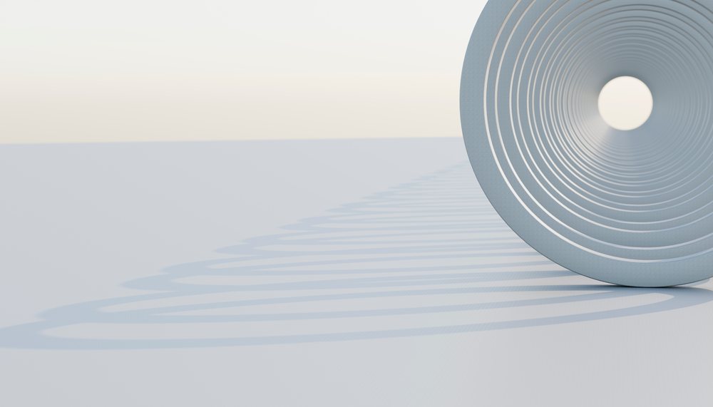 Close-up of a steel coil compression spring casting a spiral shadow