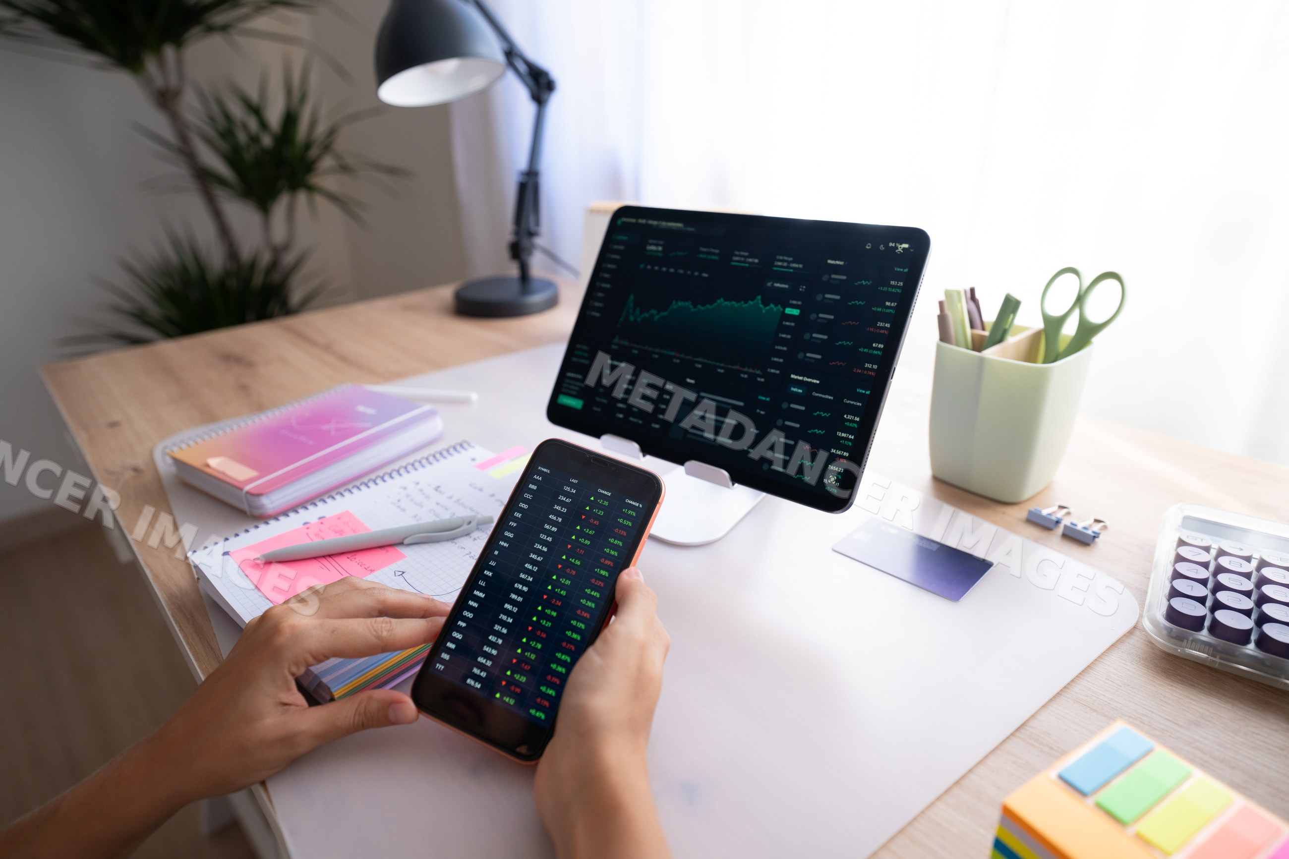 White person analyzing stock market data on smartphone and tablet