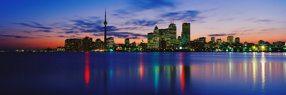 Toronto skyline reflecting on lake ontario at sunset