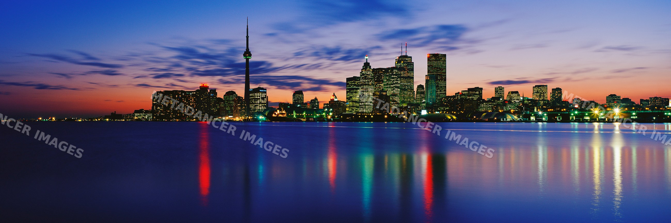 Toronto skyline reflecting on lake ontario at sunset